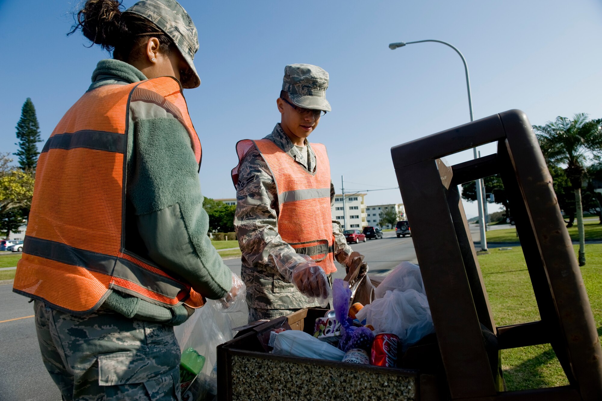 KADENA AIR BASE, Japan - Airman 1st Class Venessa Brown, 18th Logistics Readiness Squadron, and Airman 1st Class James Fotakis, 353rd Aircraft Maintenance Squadron, remove trash from a public trash can here April 5. Airmen Brown and Fotakis are first-term Airmen part of the Kadena Pride Team responsible for cleaning up the base. (U.S. Air Force photo/ Staff Sgt. Jonathan Steffen)