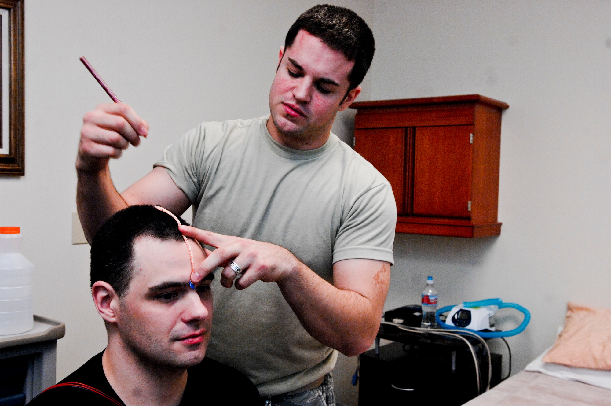 JOINT BASE ELMENDORF-RICHARDSON, Alaska - Air Force Staff Sgt. Stanley Manning, 3rd Medical Group Sleep Lab technician, marks spots on Jason Manzel, 725th Brigade Support Battalion, 4th Brigade Combat Team (Airborne), 25th Infantry Division, with a grease marker March 31. The markings allow for Manning to know where he will apply electrodes, which will be used to read Manzels brain waves while he sleeps. (U.S. Air Force photo/ Airman 1st Class Jack Sanders)