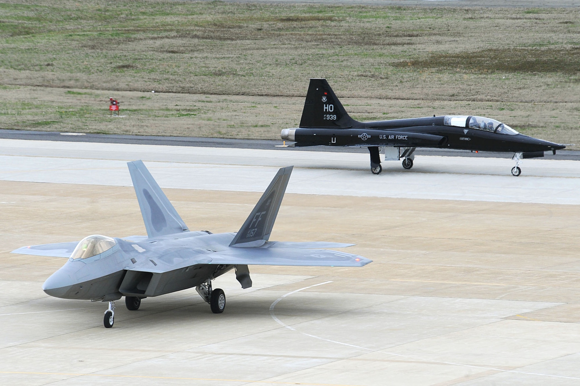 An F-22 Raptor and a T-38 Talon arrive April 1, 2011, at Langley Air Force Base, Va. The T-38 is temporarily assigned to the 1st Fighter Wing to support combat readiness training for the F-22 pilots. (U.S. Air Force photo/Senior Airman Brian Ybarbo) 