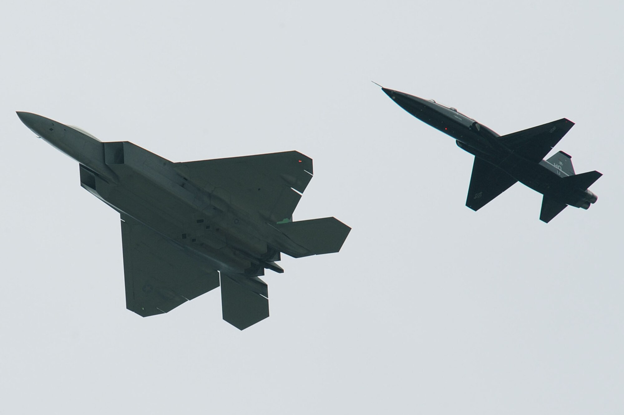 An F-22 Raptor escorts a T-38 Talon onto Langley Air Force Base, Va., April 1, 2011. The T-38, from Holloman AFB, N.M., is here for six months to help train F-22 Raptor pilots. (U.S. Air Force photo/Senior Airman Brian Ybarbo)