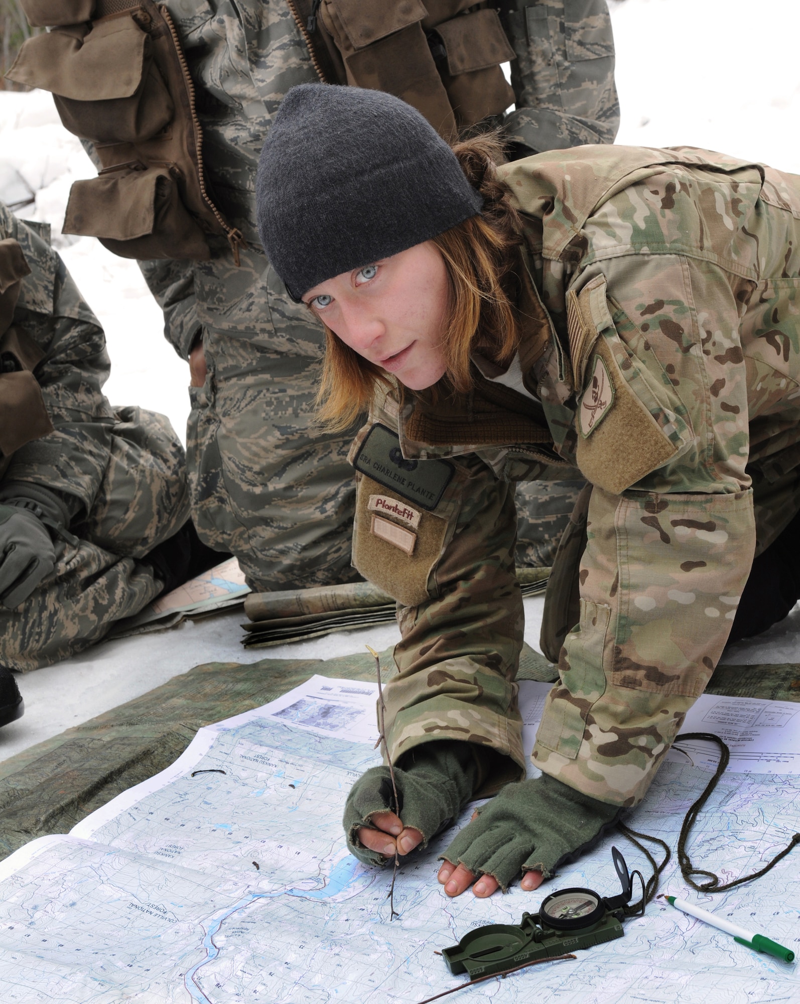 Senior Airman Charlene Plante, 22nd Training Squadron, Survival Evasion Resistance Escape specialist, teaches her students triangulation March 13, 2011 in Colville National Forest, Wash., The purpose of this block of training is to teach students how to pinpoint their location using a map, compass and sticks. (U.S. Air Force photo illustration/Tech. Sgt. JT May III)