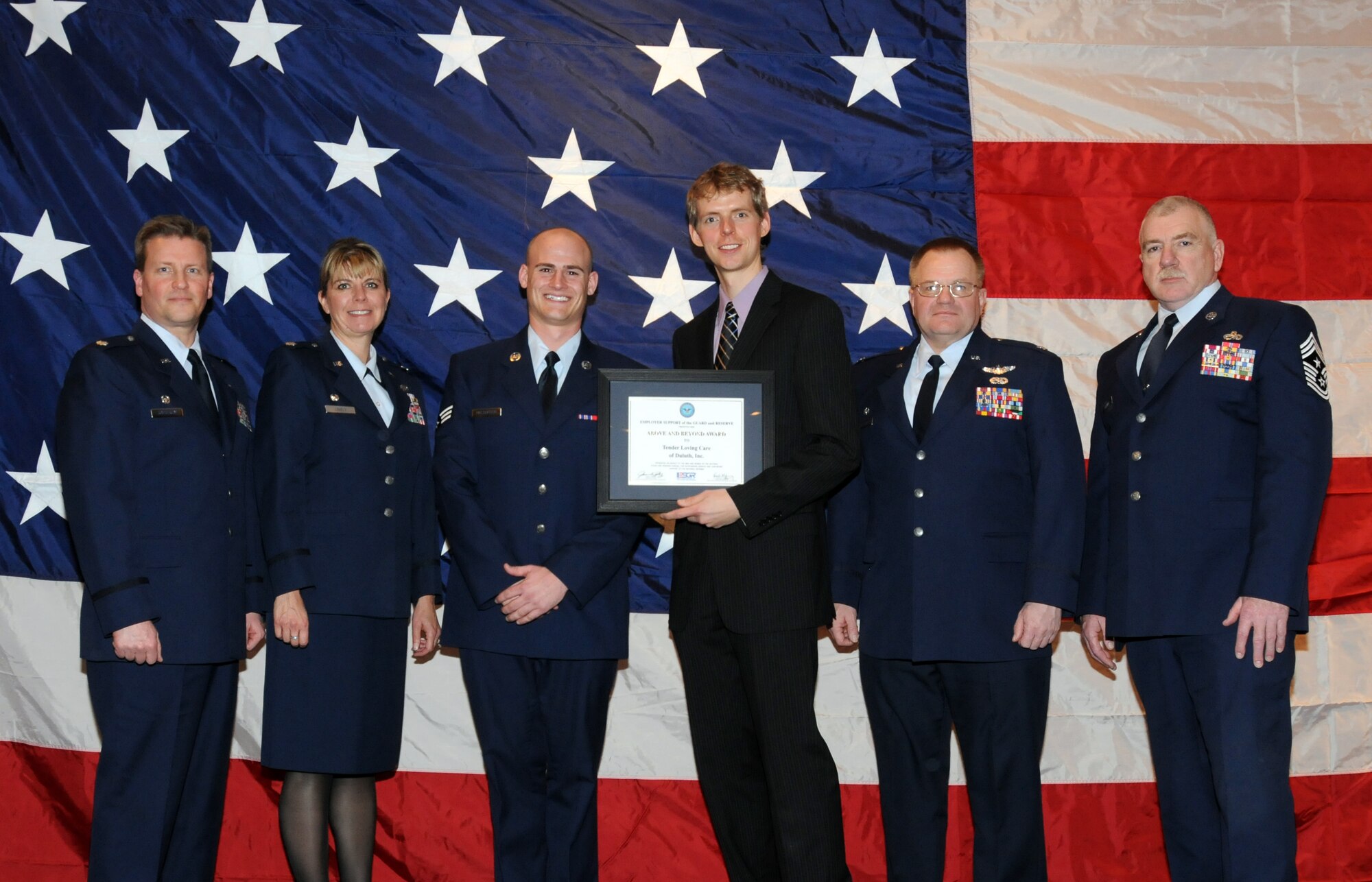 Kevin Johnson of Tender Loving Care Inc. poses for a group photo with members of the 148th Fighter Wing, Duluth, Minn. while attending a Minnesota Employer Support for the Guard and Reserve Banquet held in Oakdale, Minn.  Johnson was at the banquet to accept the "Above and Beyond Award" recognizing Tender Loving Care Inc. for its support of military employees.  (U.S. Air Force photo by Master Sgt. Ralph J. Kapustka)