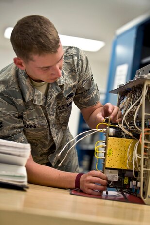 NELLIS AIR FORCE BASE, Nev.-- Airman 1st Class Joseph Harris, a Precision Measurement Equipment Laboratory apprentice assigned to the 57th Maintenance Squadron, pulls out a receiver card from a joint service electronic combat systems tester (JSECST) April 5. A JSECST  provides an end-to-end functional testing capability to determine the status of electronic systems installed in or on operational aircraft. (U.S. Air Force photo by Airman 1st Class Matthew Lancaster)