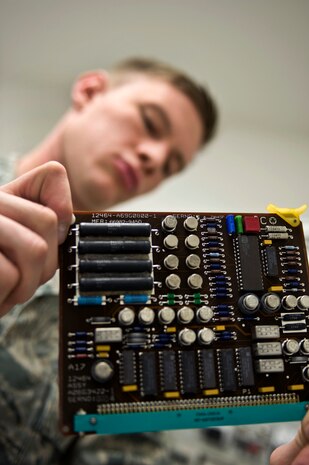 NELLIS AIR FORCE BASE, Nev.-- Senior Airman Paul Bishop, a calibration technician assigned to the 57th Maintenance Squadron, exams circuit card from a stores management subsystem test Set April 5. The test set provides the necessary shop testing of the stores release equipment of an aircraft, such as air-to-ground pylons, launchers, adapters and bomb racks. (U.S. Air Force photo by Airman 1st Class Matthew Lancaster)