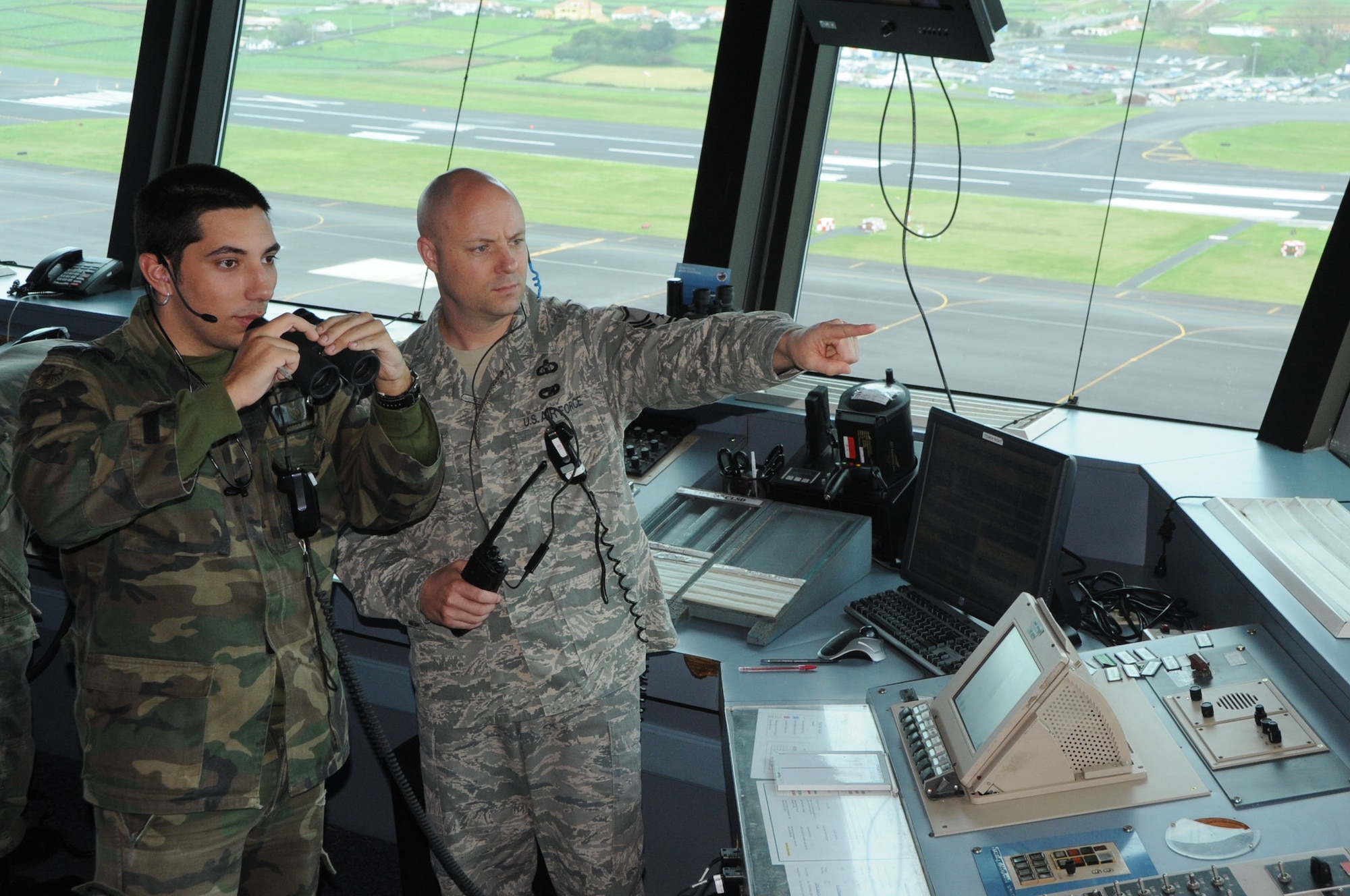 1CAB (Airman 1st Class) Jorge Ramos, portuguese air force, and Master Sgt.
Markus Fuehrmann, RAPCON/Tower air traffic control supervisor, look at an
approaching aircraft at Lajes Field, Azores, April 5, 2011.  Both air forces
work together to provide tower and radar support for approximately 1,000
aircraft operations a month.   (U.S. Air Force photo/Tech. Sgt. Chyrece Campbell)