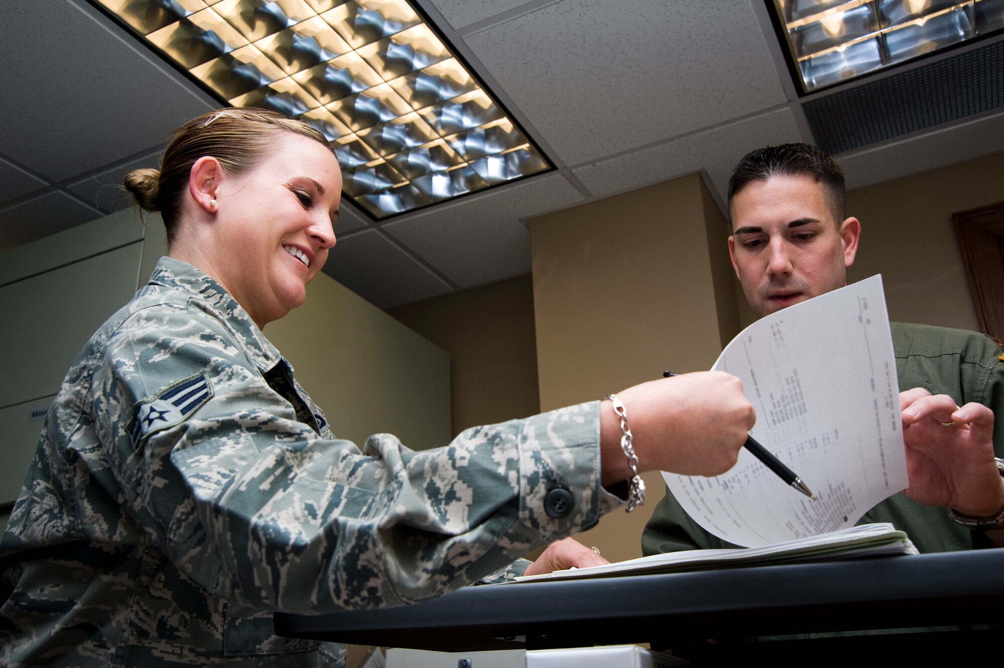 Senior Airman Rachel White, 22nd Operations Support Squadron Aviation Resource Management journeyman, performs an annual records review with Maj. Frank Rovello, Phoenix Mobility intern pilot, April 5, 2011, McConnell Air Force Base, Kan. The Danville, Va., native also maintains aircrew flight records, flying time and flight pay.  (U.S. Air Force photo/Airman 1st Class Armando A. Schwier-Morales)