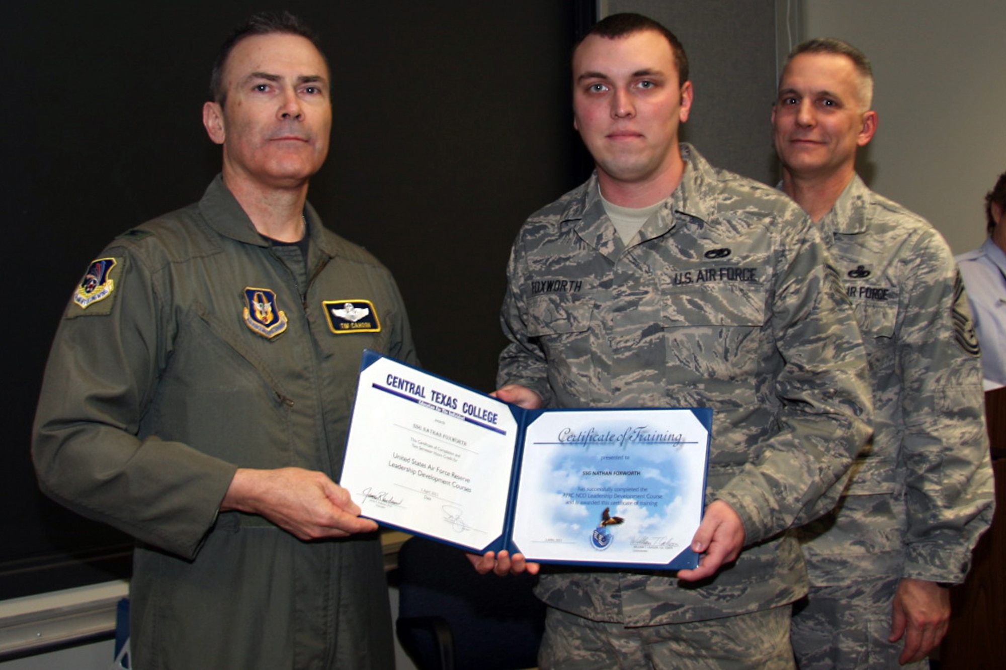 GRISSOM AIR RESERVE BASE, Ind. -- Staff Sgt. Nathan Foxworth, 434th Maintenance Squadron jet engine mechanic apprentice, accepts a noncommissioned officer leadership development course graduation certificate from Col. William T. ?Tim? Cahoon and Chief Master Sgt. Kevin Cassidy, during a NCOLDC here recently. The 10-day course teaches NCOs how to recognize good leadership practices in an organization, how to recognize the impact of power in a group, and how to develop team-building skills and other leadership qualities. Colonel Cahoon is the 434th Air Refueling Wing commander, and Sergeant Cassidy is the 434th Maintenance Squadron maintenance superintendent. (U.S. Air Force photo/Senior Airman Damon Kasberg)