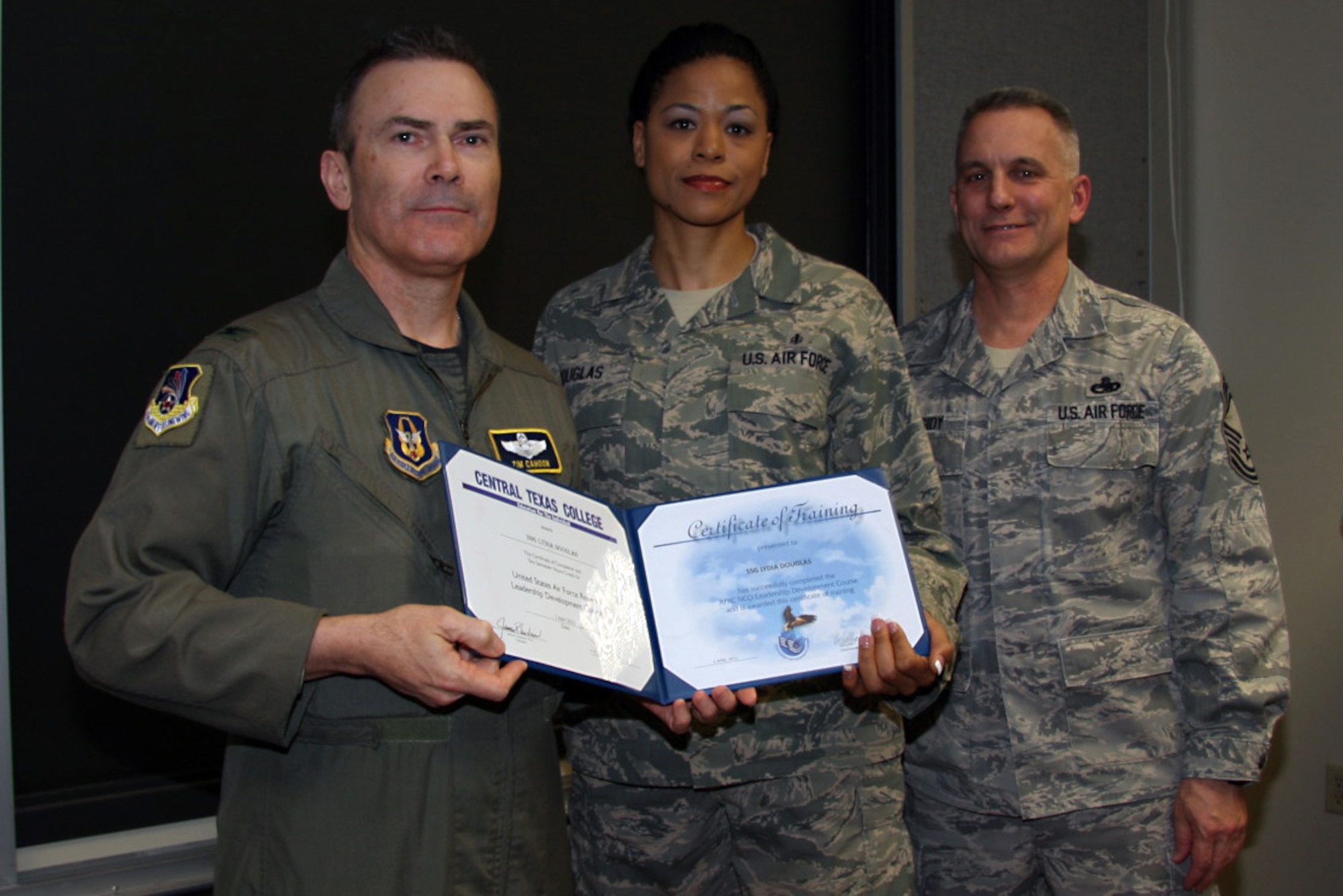 GRISSOM AIR RESERVE BASE, Ind. -- Staff Sgt. Lydia Douglas, 434th Aerospace Medicine Squadron aerospace medical service helper, is presented with a noncommissioned officer leadership development course graduation certificate by Col. William T. ?Tim? Cahoon and Chief Master Sgt. Kevin Cassidy, during a NCOLDC graduation here recently. The Air Force Reserve Command NCOLDC was established in 1989 in response to a need to provide meaningful and challenging leadership training to mid-level enlisted personnel. Colonel Cahoon is the 434th Air Refueling Wing commander, and Sergeant Cassidy is the 434th Maintenance Squadron maintenance superintendent. (U.S. Air Force photo/Senior Airman Damon Kasberg)