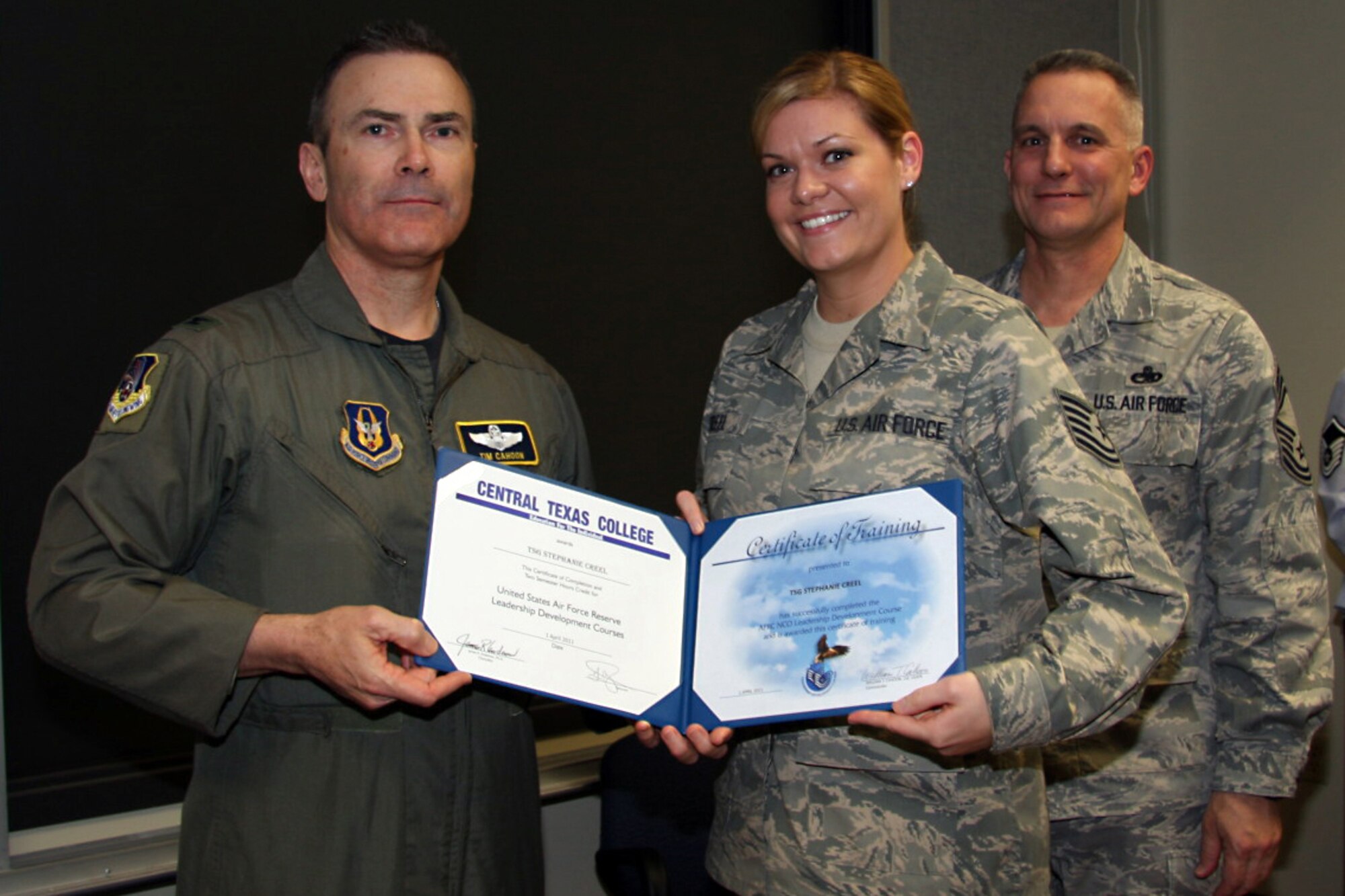 GRISSOM AIR RESERVE BASE, Ind. -- Tech. Sgt. Stephanie Creel, 434th Aerospace Medicine Squadron medical lab technician, accepts a noncommissioned officer leadership development course graduation certificate from Col. William T. ?Tim? Cahoon and Chief Master Sgt. Kevin Cassidy, during a NCOLDC here recently. The 10-day course teaches NCOs how to recognize good leadership practices in an organization, how to recognize the impact of power in a group, and how to develop team-building skills and other leadership qualities. Colonel Cahoon is the 434th Air Refueling Wing commander, and Sergeant Cassidy is the 434th Maintenance Squadron maintenance superintendent. (U.S. Air Force photo/Senior Airman Damon Kasberg)