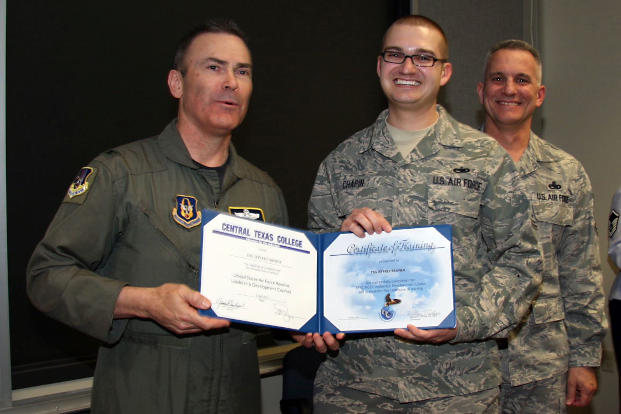 GRISSOM AIR RESERVE BASE, Ind. -- Tech. Sgt. Zachary Chapin, 434th Maintenance Squadron aerospace ground equipment specialist, is presented with a noncommissioned officer leadership development course graduation certificate by Col. William T. ?Tim? Cahoon and Chief Master Sgt. Kevin Cassidy, during a NCOLDC graduation here recently. The Air Force Reserve Command NCOLDC was established in 1989 in response to a need to provide meaningful and challenging leadership training to mid-level enlisted personnel. Colonel Cahoon is the 434th Air Refueling Wing commander and Sergeant Cassidy is the 434th Maintenance Squadron maintenance superintendent. (U.S. Air Force photo/Senior Airman Damon Kasberg)