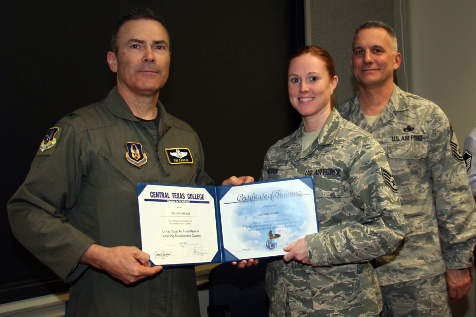 GRISSOM AIR RESERVE BASE, Ind. -- Staff Sgt. Jeni Ahearn, 434th Aerospace Medicine Squadron information specialist, accepts a noncommissioned officer leadership development course graduation certificate from Col. William T. ?Tim? Cahoon and Chief Master Sgt. Kevin Cassidy, during a NCOLDC here recently. The 10-day course teaches NCOs how to recognize good leadership practices in an organization, how to recognize the impact of power in a group, and how to develop team-building skills and other leadership qualities. Colonel Cahoon is the 434th Air Refueling Wing commander, and Sergeant Cassidy is the 434th Maintenance Squadron maintenance superintendent. (U.S. Air Force photo/Senior Airman Damon Kasberg)