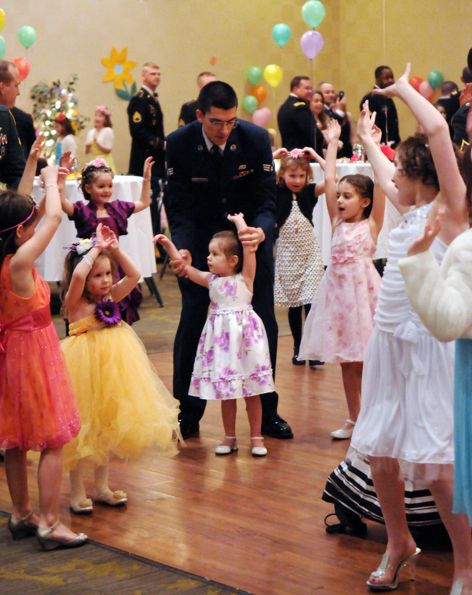Attendees to the Armed Services YMCA's Father Daughter Ball wave their arms in response to the DJ's request April 3, 2011, Eielson Air Force Base, Alaska. The father daughter ball let active duty, guard, and retired fathers share a special evening with their daughters. (U.S. Air Force photo/Airman 1st Class Janine Thibault)