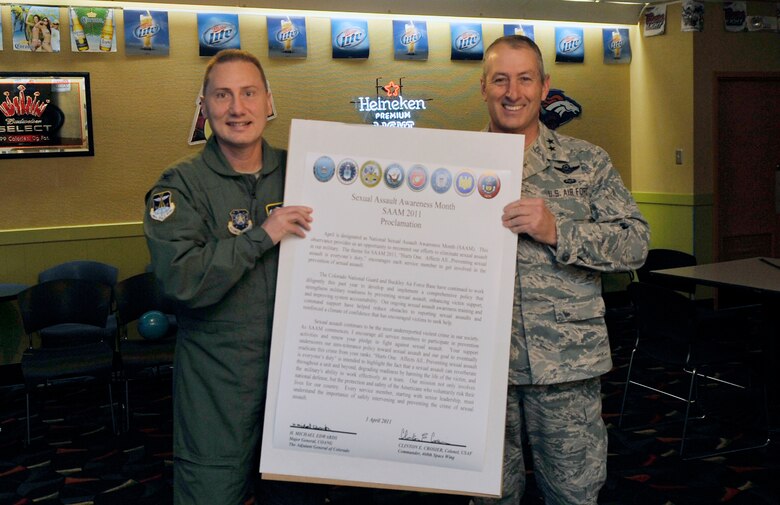 BUCKLEY AIR FORCE BASE, Colo. -- Col. Clint Crosier, 460th Space Wing commander, and Maj. Gen. H. Michael Edwards, Colorado Air national Guard adjutant general holds up the Sexual Assault Awareness Month Proclamation April 1, 2011. The proclamation designates the month of April as Sexual Assualt Awareness Month and to help raise awareness among military personal. (U.S. Air Force photo by Airman 1st Class Paul Labbe)
