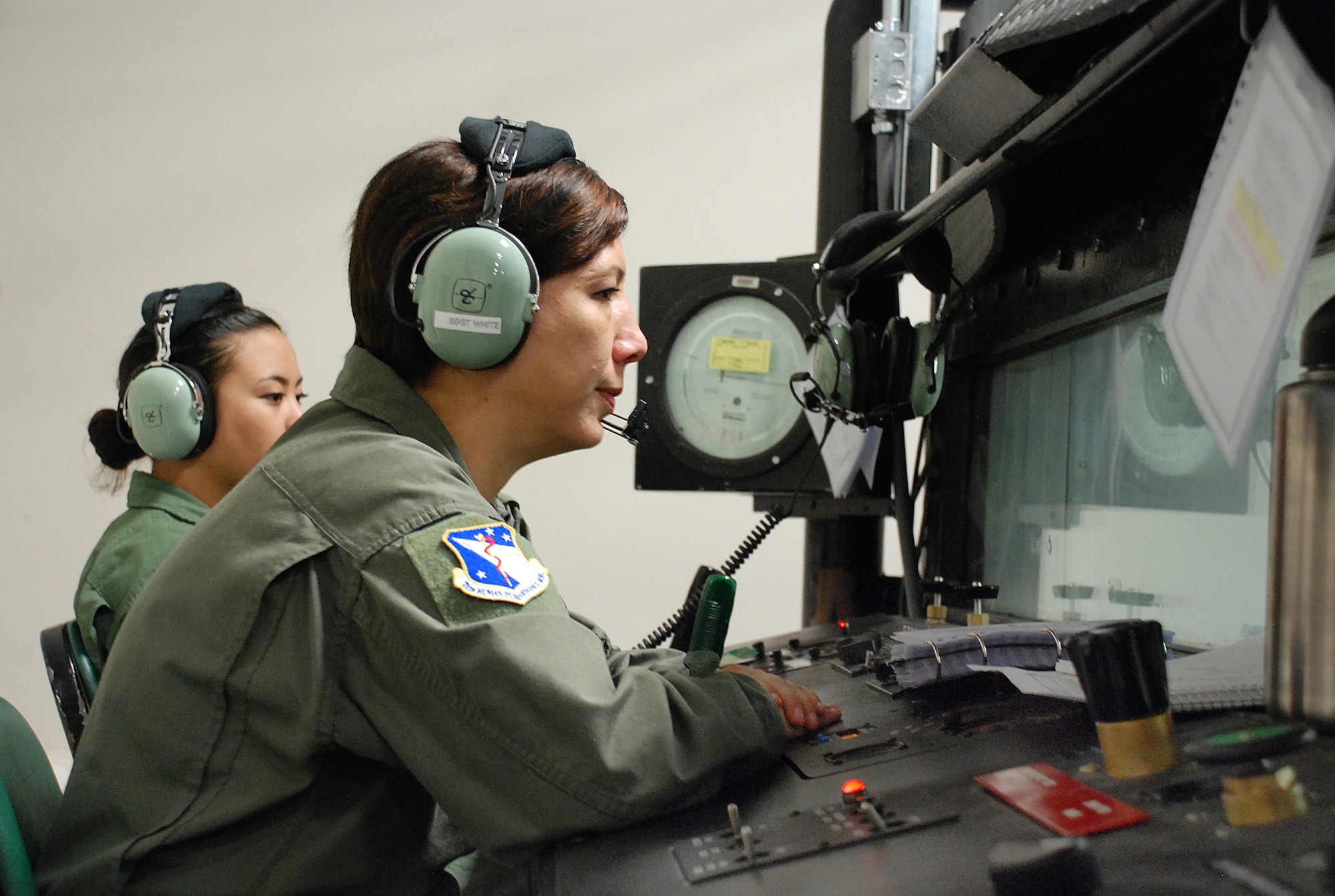 Master Sergeant Michele Armstrong (foreground) guides the United States Air Force School of Aerospace Medicine’s (USAFSAM’s) altitude chamber flight at Wright-Patterson Air Force Base (WPAFB), Ohio. Airman Kristyn Gonzales (background) operates the altitude chamber. (U.S. Air Force photo by Chris Gulliford)