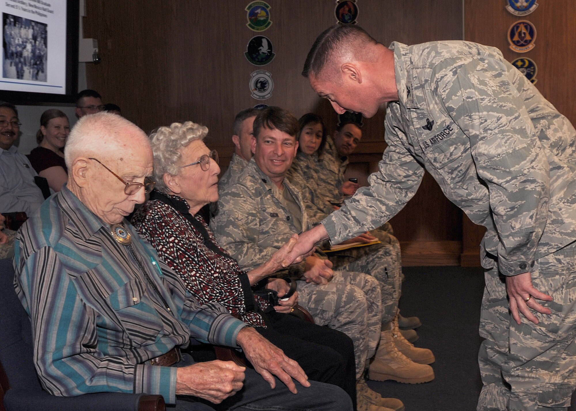 Buren and Lucille Johnson receive a coin by U.S. Air Force Col. Stephen Clark, 27th Special Operations Wing commander on Cannon Air Force Base, N.M. on April 5, 2011.  Mr. Johnson was part of the 200th Coast Artillery, N.M. National Guard during the April 9, 1942 Bataan Death March where Army, Army Air Corps, Navy and Marines were surrendered to Japanese Forces.  (U.S Air Force photo by Senior Airman James Bell) 