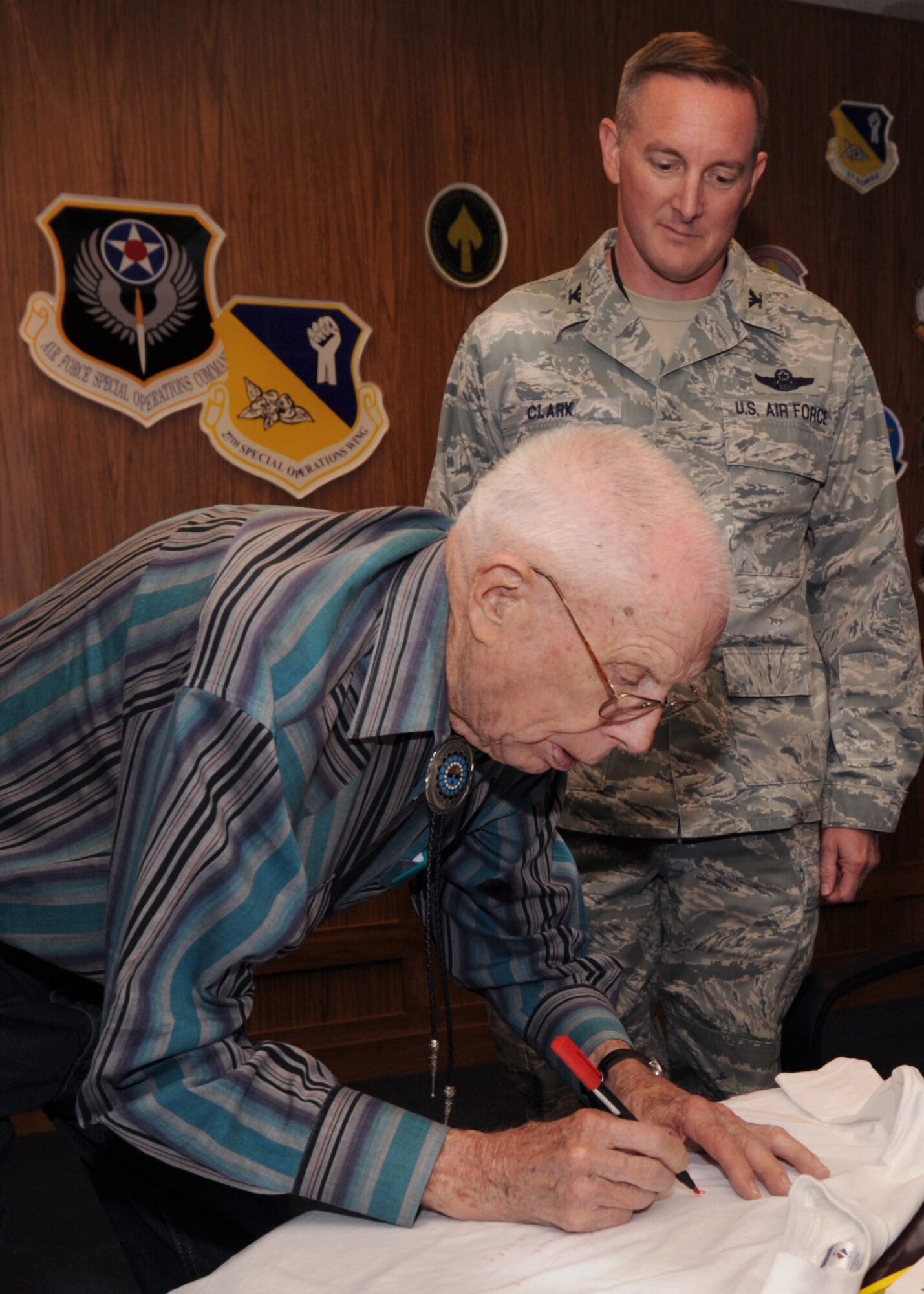 Mr. Buren Johnson, the local last surviving Bataan Death March member, signs a shirt for U.S. Air Force Col. Stephen Clark, 27th Special Operations Wing commander on Cannon Air Force Base, N.M. on April 5, 2011.  Out of 72,000 Mr. Johnson was part of the 54,000 people that actually made it through the Bataan Death March April 9, 1942.  (U.S Air Force photo by Senior Airman James Bell)