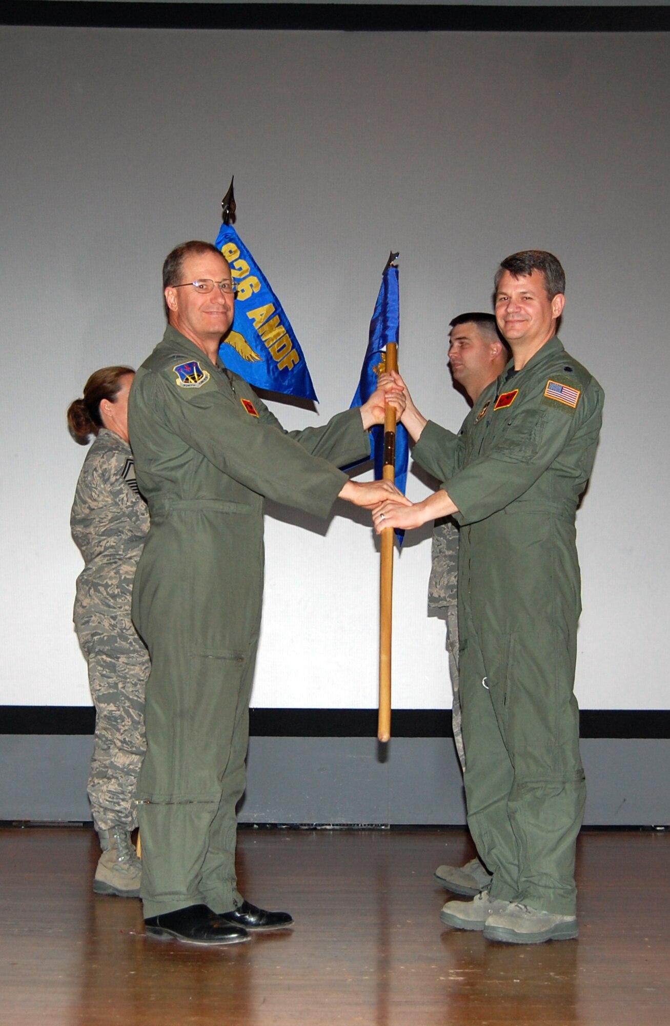 NELLIS AIR FORCE BASE, Nev. -- (Right) Lt. Col. John Langell, 926th Aerospace Medicine Squadron commander, receives the guideon from Col. Herman Brunke, Jr., 926th Group commander, here April 2 recognizing the flight's transition to a squadron effective March 1. The squadron is made up of more than 40 personnel, providing medical and dental exams, immunizations, lab work, and initial flying class physicals to the group's local members. (U.S. Air Force photo/Capt. Jessica Martin)