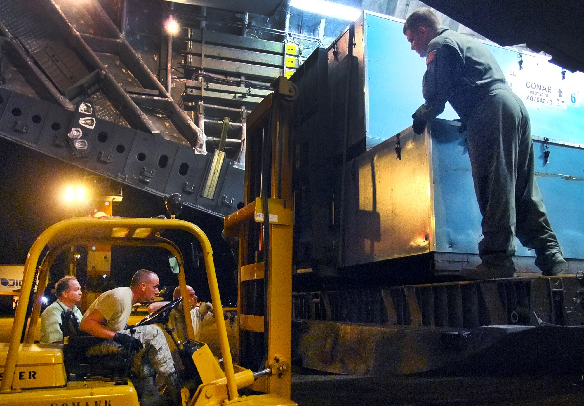 Senior Master Sgt. Matt McElreath, 67th Aerial Port Squadron, loads NASA satellite equipment, as fellow aerial porter Tech. Sgt. James Girardo spots him. The reservists loaded and unloaded more than 100,000 pounds of cargo during the 10-day endeavor. (Courtesy photo)