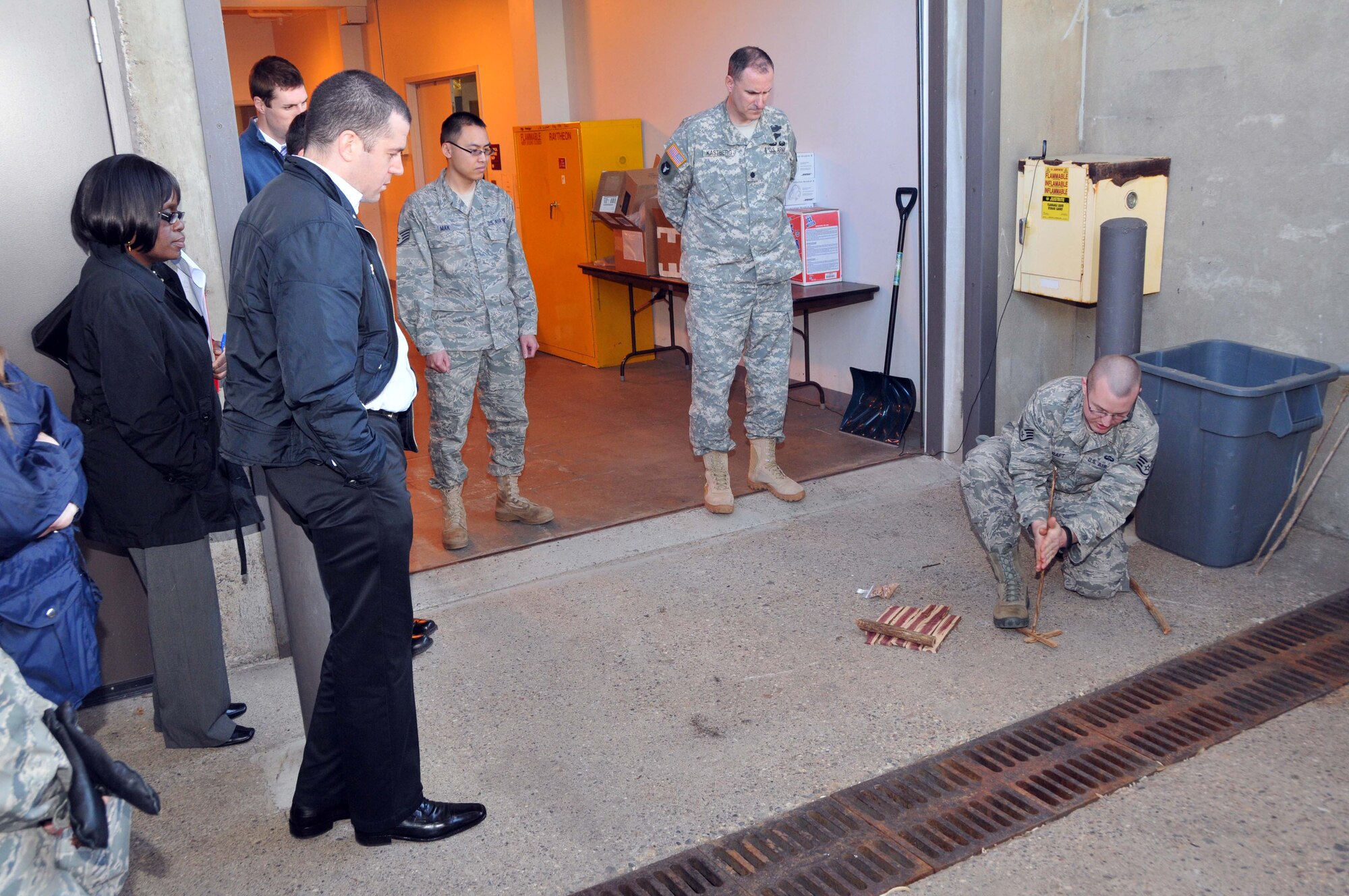 Staff Sgt. Adam Craft, 934th Airlift Wing Survival, Evasion, Resistance and Escape specialist, demonstrates how to build a fire in the wild using friction and commonly found wood for members of the Federal Outreach Leadership Development program tour April 5.  (Air Force Photo/Paul Zadach)
