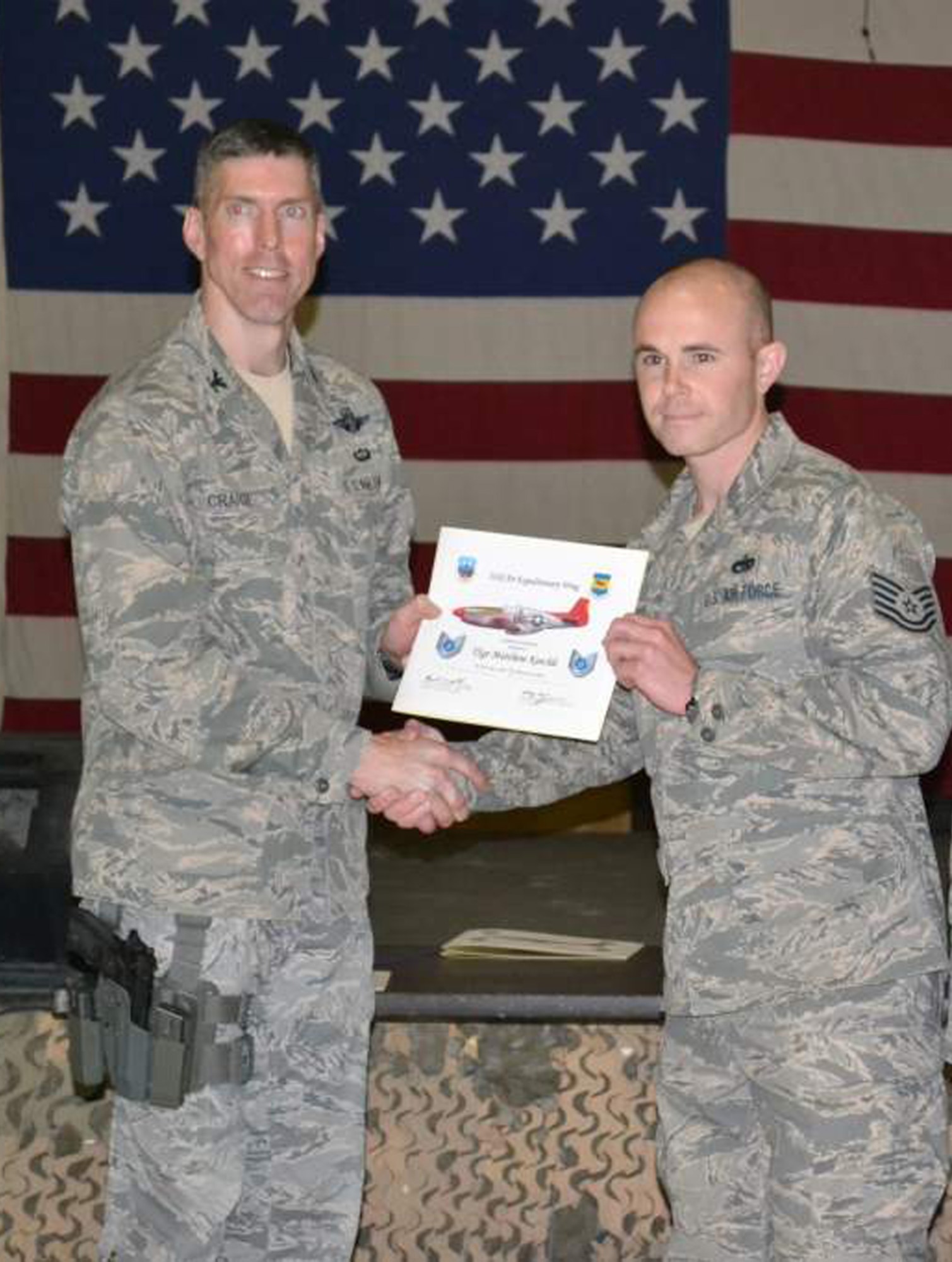 WRIGHT-PATTERSON AIR FORCE BASE, Ohio – Col. Christopher E. Craige, 332nd AEW vice commander, presents Tech. Sgt. Matthew Keechle, 87th Aerial Port Squadron currently deployed with the 332nd Expeditionary Logistics Readiness Squadron, Joint Base Balad, Iraq, with a certificate for his recent promotion to technical sergeant. (Courtesy photo) 