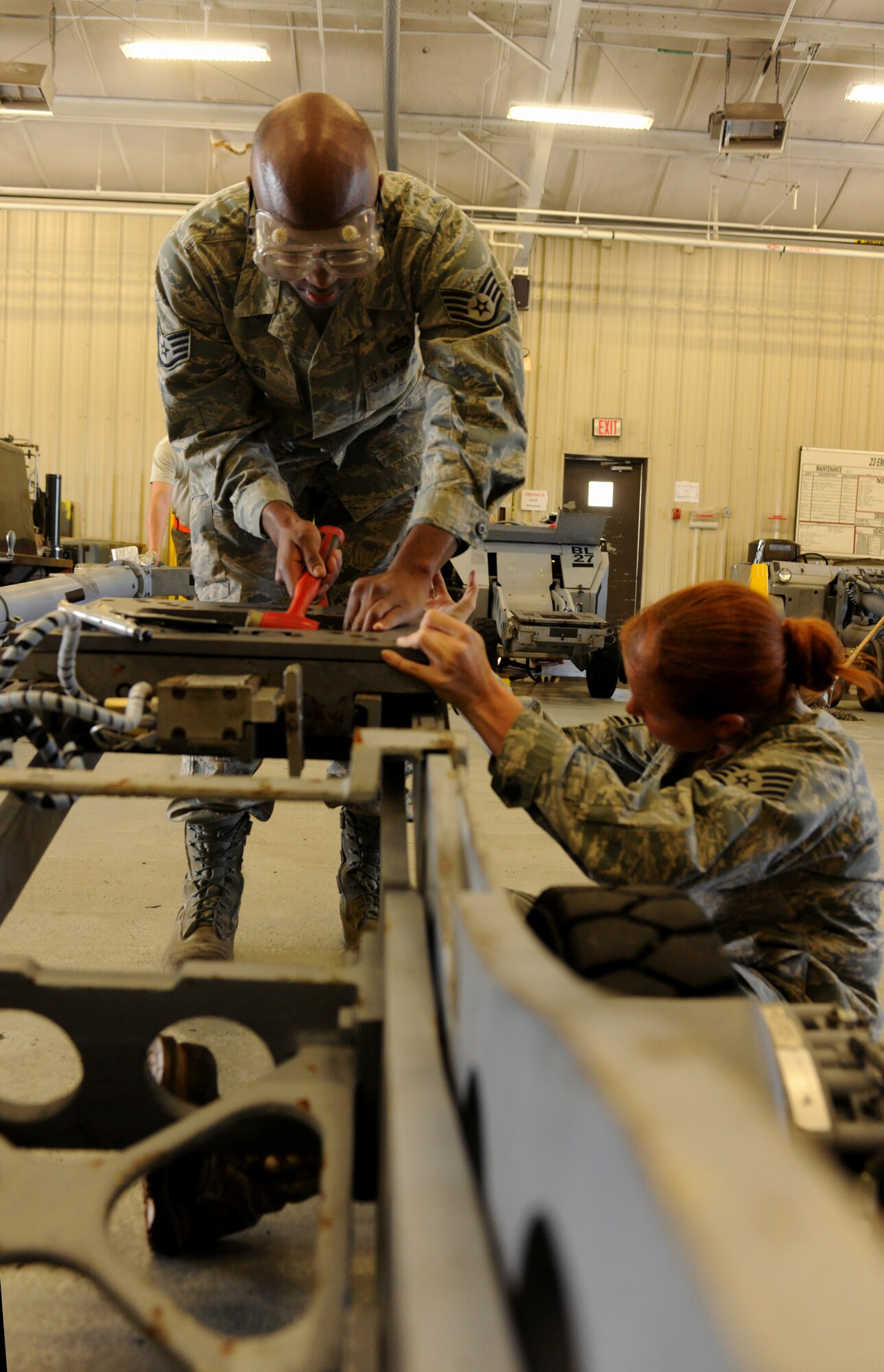 Staff Sgts. Lindsay Shaw and Jaiopalanta Jones, 23rd Equipment Maintenance Squadron aerospace ground equipment maintenance craftsmen, repair a table assembly on a bomb lift at the AGE compound April 5. The bomb lift table assembly is vital in the safe installation of weaponry on the A-10C Thunderbolt II aircraft featured at Moody Air Force Base, Ga.  (U.S. Air Force photo/Airman 1st Class Benjamin Wiseman)(RELEASED)