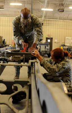 Staff Sgts. Lindsay Shaw and Jaiopalanta Jones, 23rd Equipment Maintenance Squadron aerospace ground equipment maintenance craftsmen, repair a table assembly on a bomb lift at the AGE compound April 5. The bomb lift table assembly is vital in the safe installation of weaponry on the A-10C Thunderbolt II aircraft featured at Moody Air Force Base, Ga.  (U.S. Air Force photo/Airman 1st Class Benjamin Wiseman)(RELEASED)