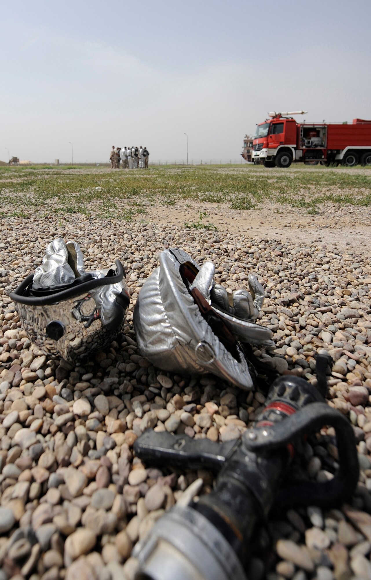 KIRKUK REGIONAL AIR BASE, Iraq – Iraqi air force and U.S.-contracted firefighters huddle for debrief after completing a joint C-130 crash simulation exercise April 3. The U.S. Air Force base transition team at Kirkuk spearheaded the exercise with a dozen American and Iraqi firefighters to improve communication and joint tactics between the two fire departments. (U.S. Air Force/Tech. Sgt. Jason Lake)
