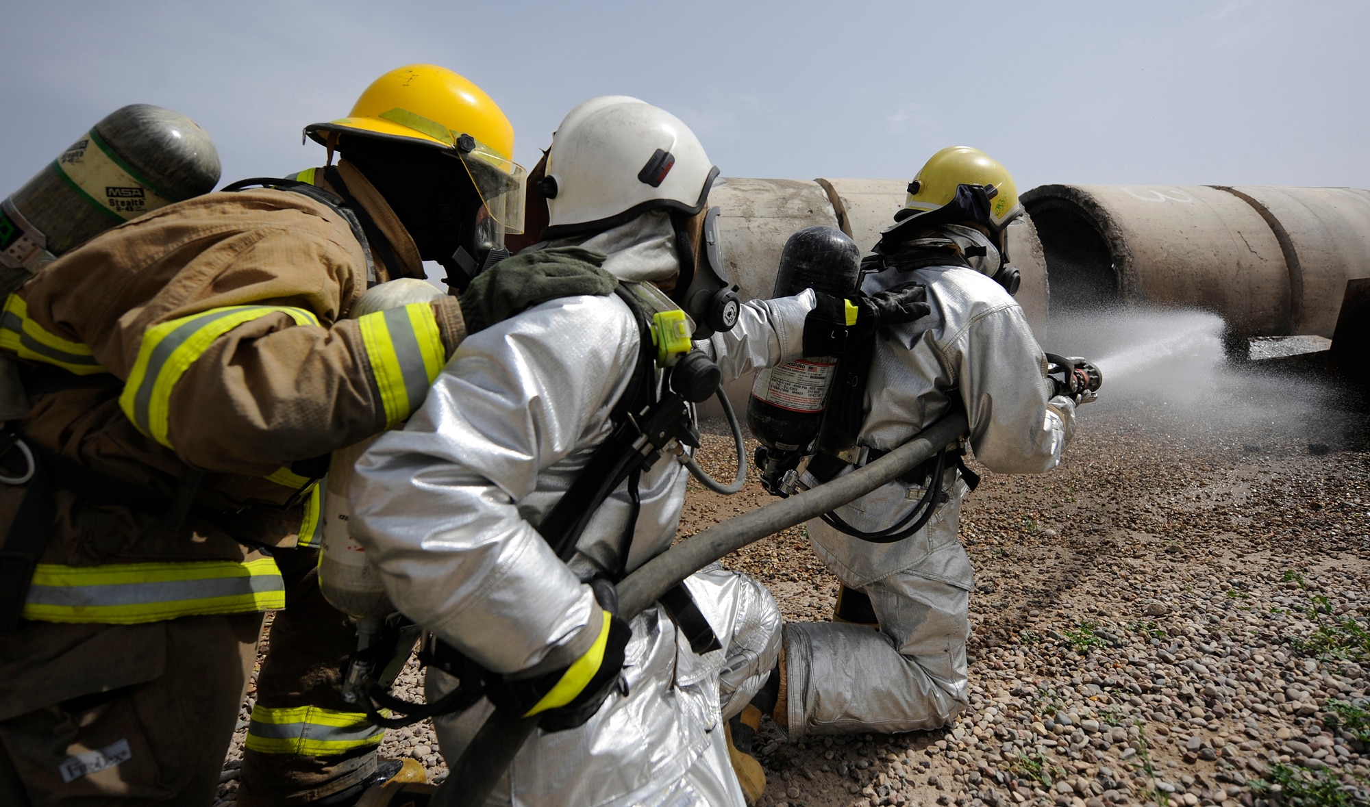 KIRKUK REGIONAL AIR BASE, Iraq – Iraqi air force firefighters and U.S.-contracted firefighters work together to extinguish a simulated C-130 crash site during an exercise April 3. Kirkuk's base transition team spearheaded the exercise with a dozen American and Iraqi firefighters to improve communication and joint tactics between the two fire departments. (U.S. Air Force/Tech. Sgt. Jason Lake)