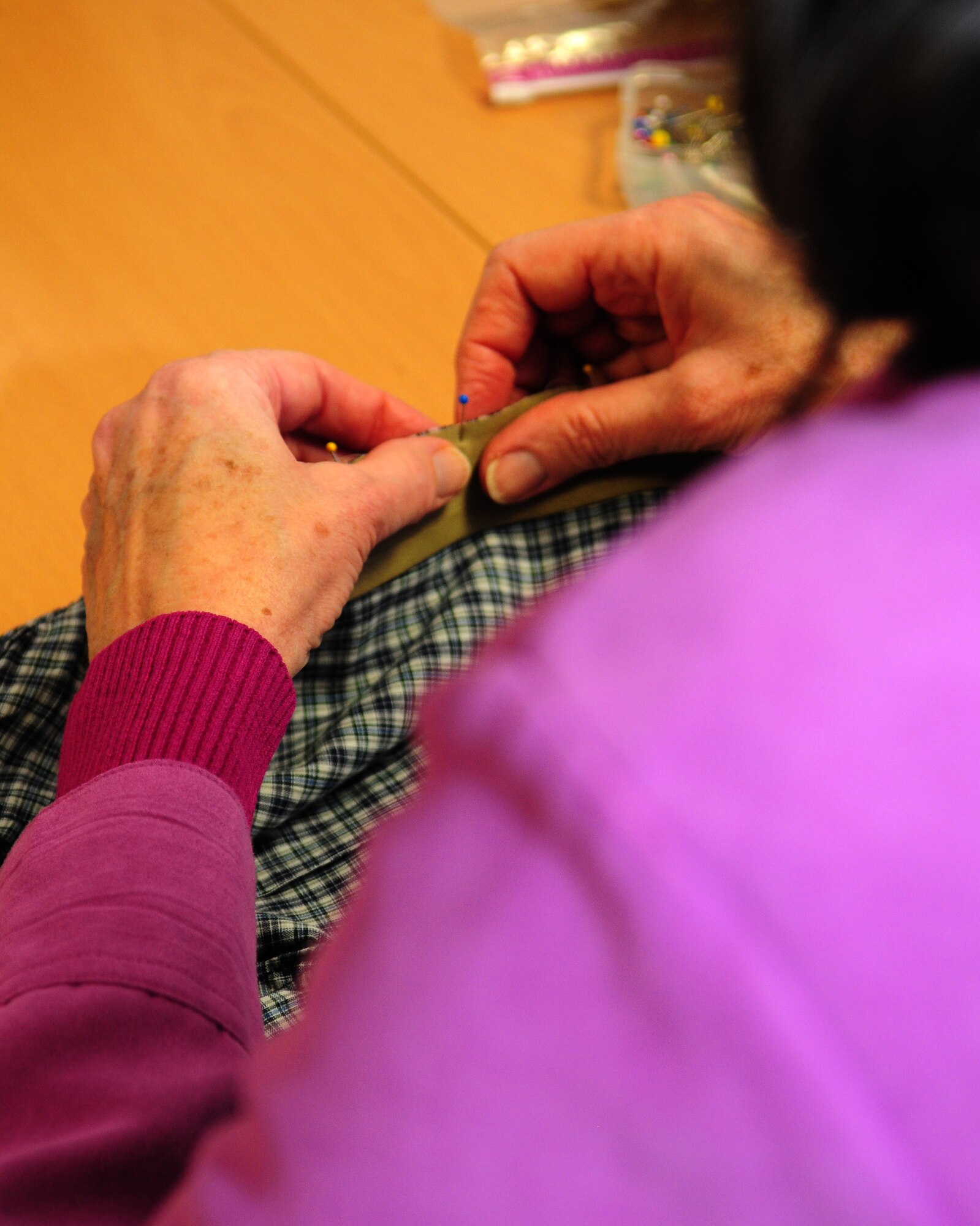 SPANGDAHLEM AIR BASE, Germany —A Sew Much Comfort volunteer pins fabric fastener strips to a pair of underwear to be sewn March 31 at the Airman and Family Readiness Center here. Sew Much Comfort modifies underwear to be used by wounded warriors with limited mobility. Volunteers have been meeting monthly for more than two years and produce about 150 pairs of modified undergarments annually at the Landstuhl Regional Medical Center in Landstuhl, Germany. (U.S. Air Force Photo/Airman 1st Class Dillon Davis)