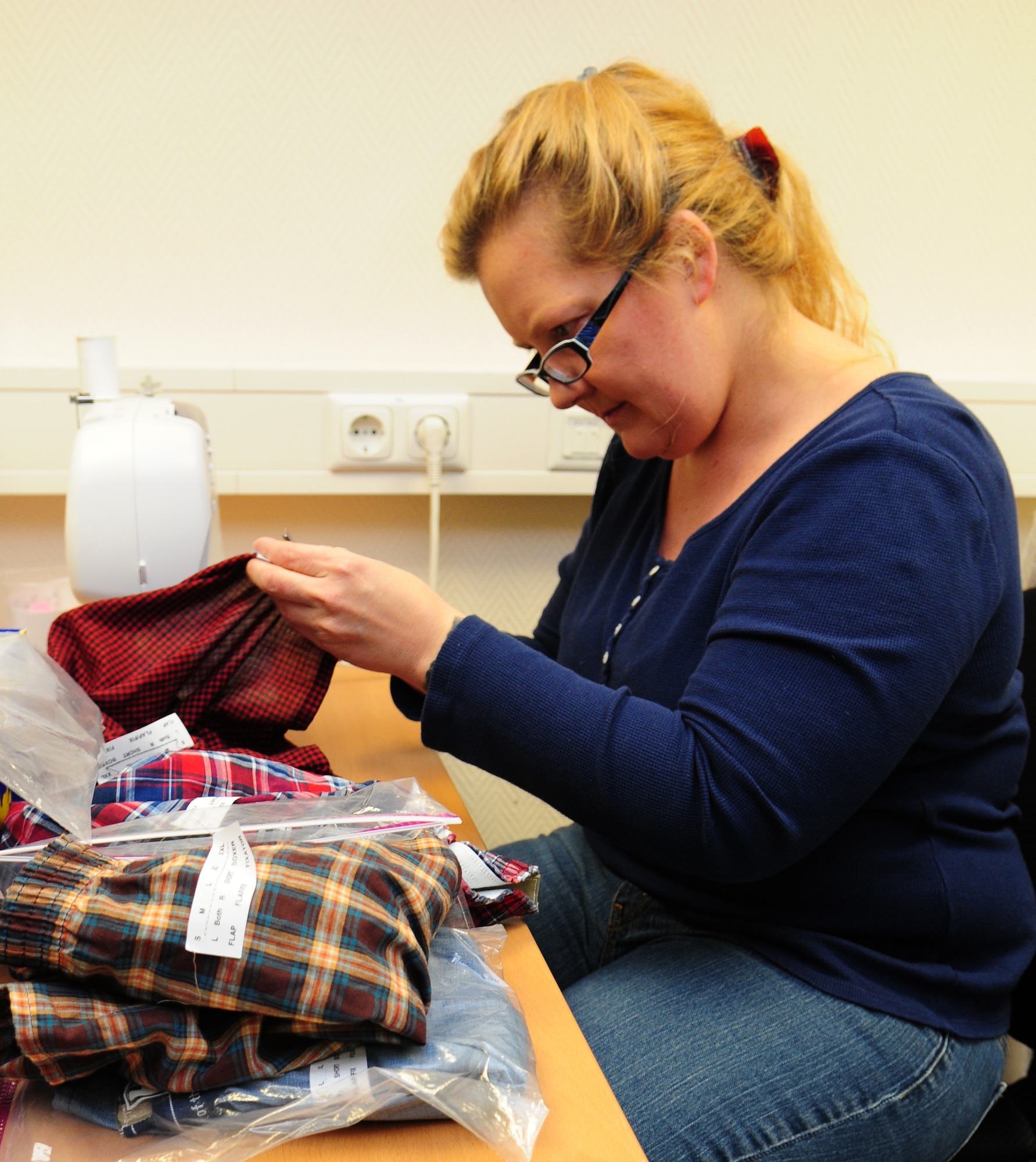 SPANGDAHLEM AIR BASE, Germany —Kristen Burzumato, director of the Spangdahlem chapter of Sew Much Comfort, prepares to sew fabric fastener strips on a pair of underwear March 31 at the Airman and Family Readiness Center here. Sew Much Comfort modifies underwear to be used by wounded warriors with limited mobility. Volunteers have been meeting monthly for more than two years and produce about 150 pairs of modified undergarments annually at the Landstuhl Regional Medical Center in Landstuhl, Germany. (U.S. Air Force Photo/Airman 1st Class Dillon Davis)