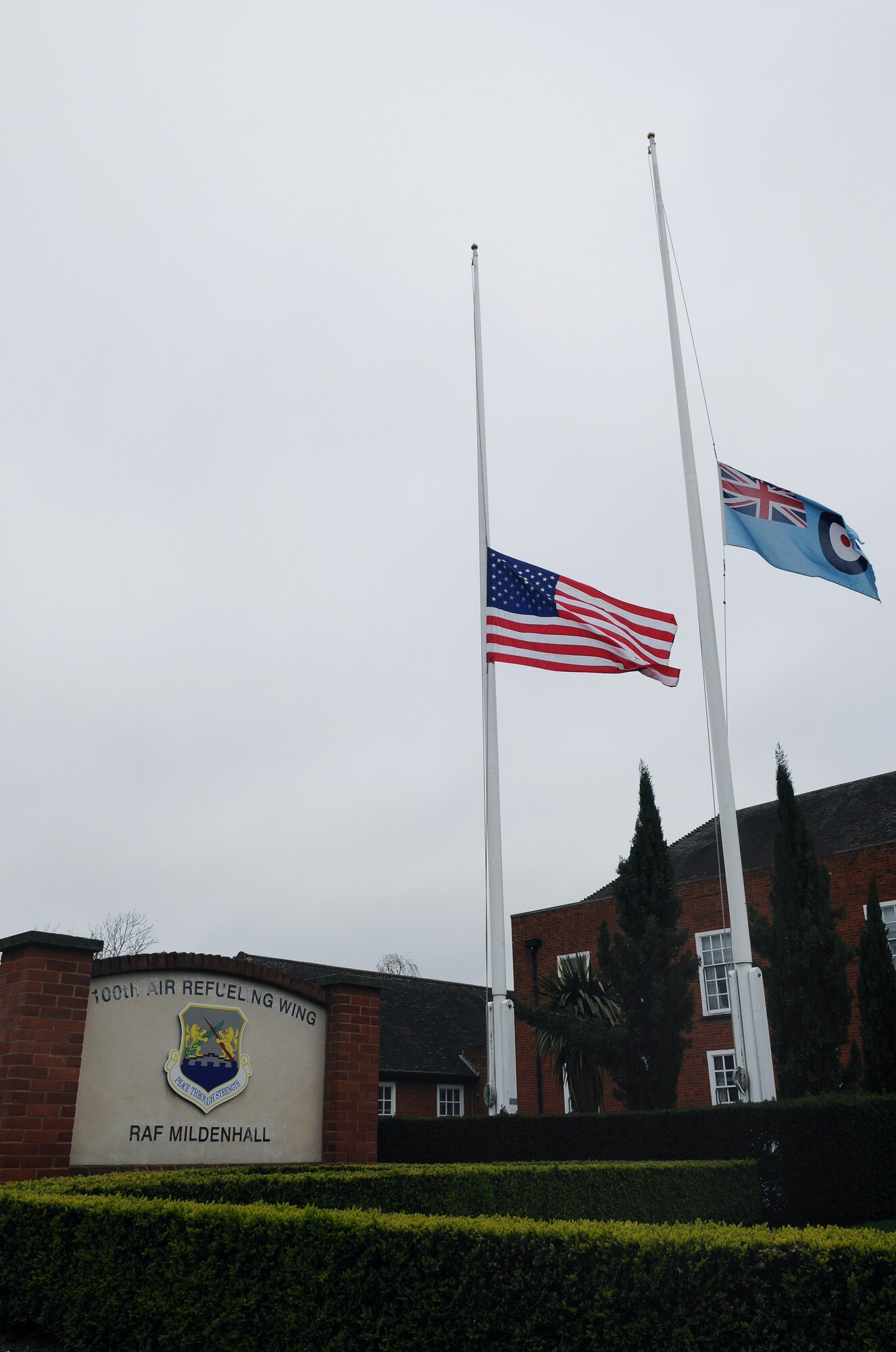 RAF MILDENHALL, England -- The base flags are flown at half staff outside the 100th Air Refueling Wing headquarters building here April 6, 2011, in memory of Staff Sgt. Bradly Ring, 95th Reconnaissance Squadron. Sergeant Ring, a maintenance technician, died April 2 in a two-car vehicle accident on Mildenhall Road near the Shippea Hill train station. (U.S. Air Force photo/Staff Sgt. Thomas Trower)