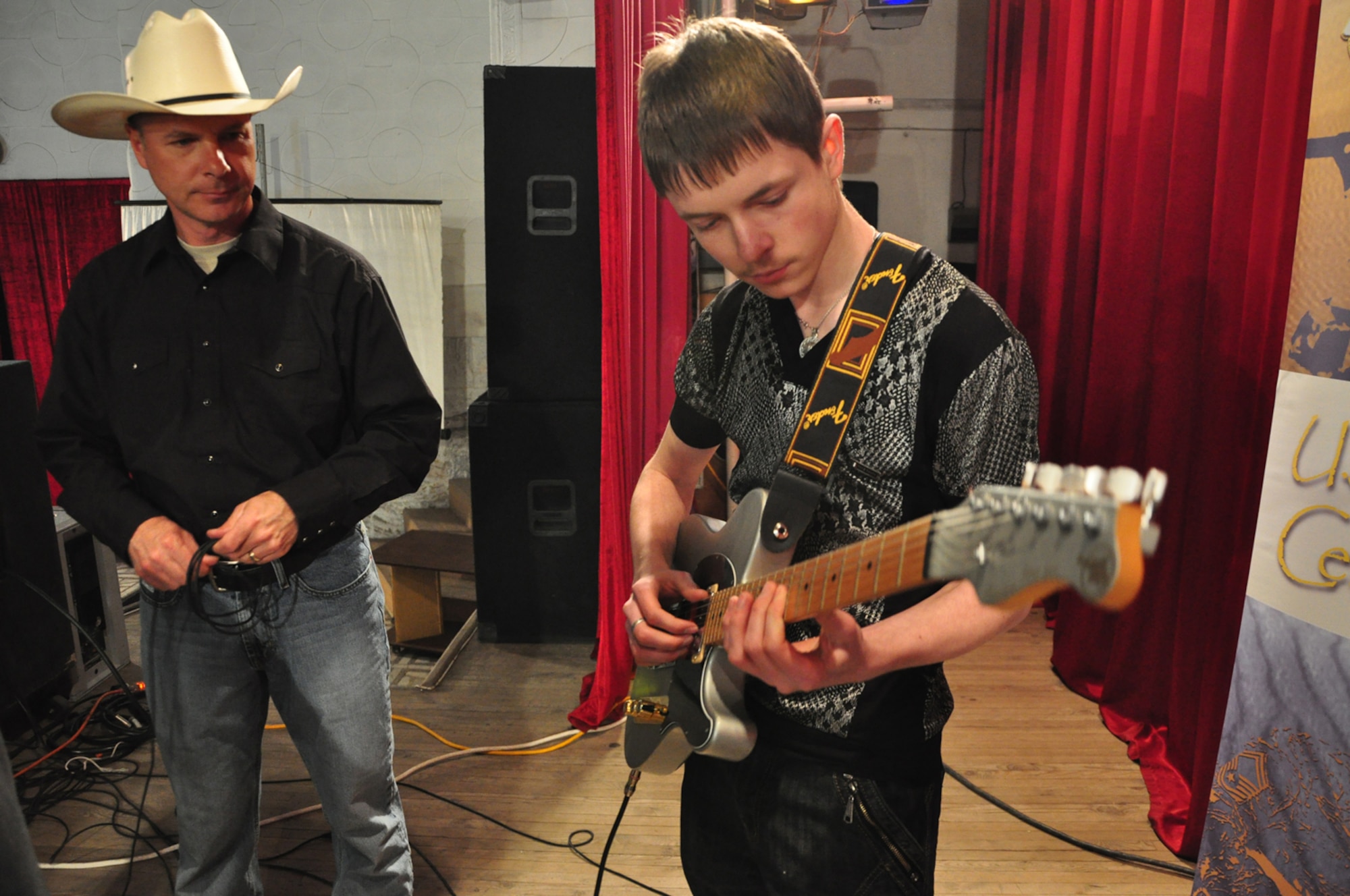 Tech. Sgt. Stephen Brannen watches a young Kyrgyzs student play the guitar after a Wild Blue Country performance at the House of Culture in Kant April 5. Wild Blue Country, the current AFCENT band deployed to the Central Command Area of Responsibility, is currently on tour in the Republic of Kyrgyzstan. The band hails from Peterson Air Force Base, Colorado Springs, Colo. (U.S. Air Force photo/Master Sgt. Daniel Nathaniel)