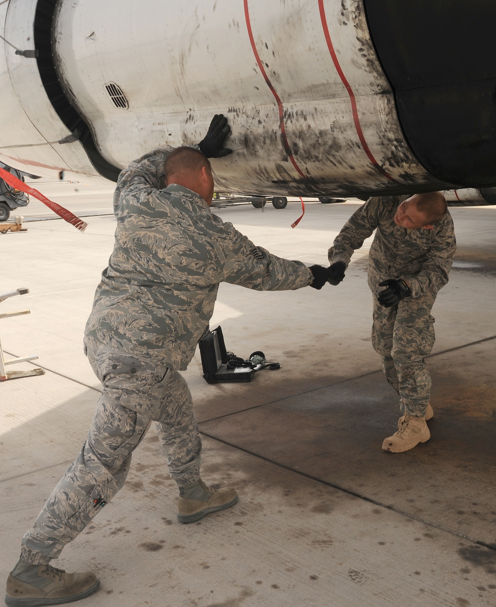 Tech. Sgt. Al Beck and Airman 1st Class Kyle Beck, 7th Expeditionary Aircraft Maintenance Unit, work together on an E-8 Joint Surveillance Attack Radar System aircraft at an undisclosed location in Southwest Asia, March 31.  (U.S. Air Force photo/Staff Sgt. Liliana Moreno)                                