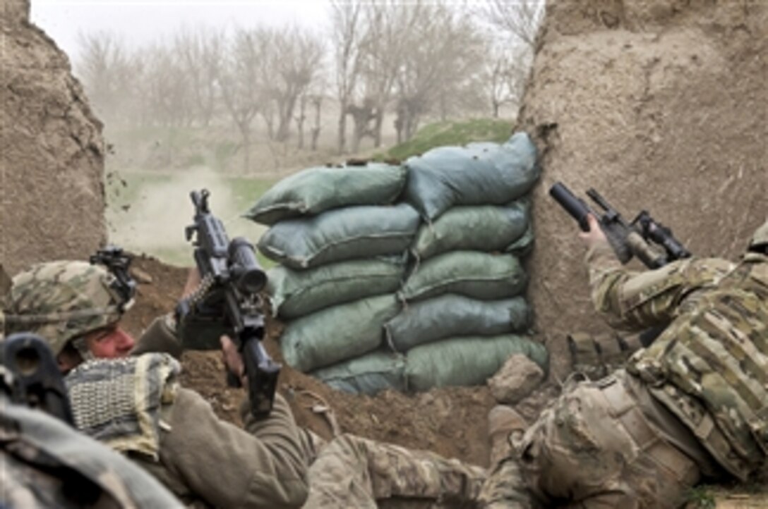 U.S. Army Pfc. Ben Bradley (left) ducks away from small-arms fire as fellow scout Sgt. Jeff Sheppard launches a grenade at the enemyís position during a combat engagement in northern Bala Murghab valley in Afghanistan's Baghdis province on April 4, 2011.  Bradley is a scout assigned to the 7th Squadron, 10th Cavalry Regiment.  