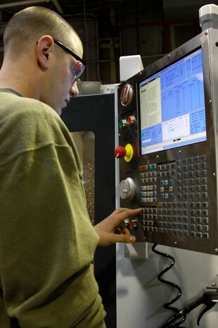 Lance Cpl. Joshua Lucie, a Marine Aviation Logistics Squadron 12 machinist, inputs information into the Computer Numerical Control Vertical Toolroom Mill 1 to create a part in the MALS-12 aviation life support building April 6. The machine specializes in machining hard metals to create parts used in other machines.