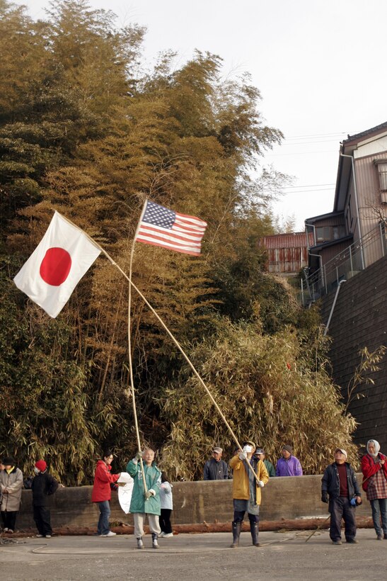 Two elderly residents of Oshima Island wave the Japanese and American flags as a way of thanking Marines and Sailors of the 31st Marine Expeditionary Unit, for their hard work, April 7. The Marines and Sailors spent about six days cleaning up debris on parts of the island, during Operation Field Day. The 31st MEU's involvement is part of the larger Operation Tomodachi, coordinated after a 9.0 earthquake and subsequent tsunami struck Japan causing widespread damage. The 31st MEU remains ready to support its Japanese partners and to provide assistance when called upon.