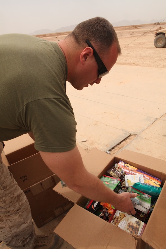 Cpl. David B. Gurney, an aircraft rescue firefighter with Marine Wing Support Squadron 272, sorts through a box of goods at Forward Operating Base Edinburgh, Afghanistan, April 7. Sgt. Christopher L. Preston and Cpl. George N. English, who both provide security for the 2nd Marine Aircraft Wing (Forward) command group, gathered and delivered additional supplies for fellow Marines. “It’s exciting getting things out here that we don’t have,” said Gurney, a native of Jacksonville, Fla.
