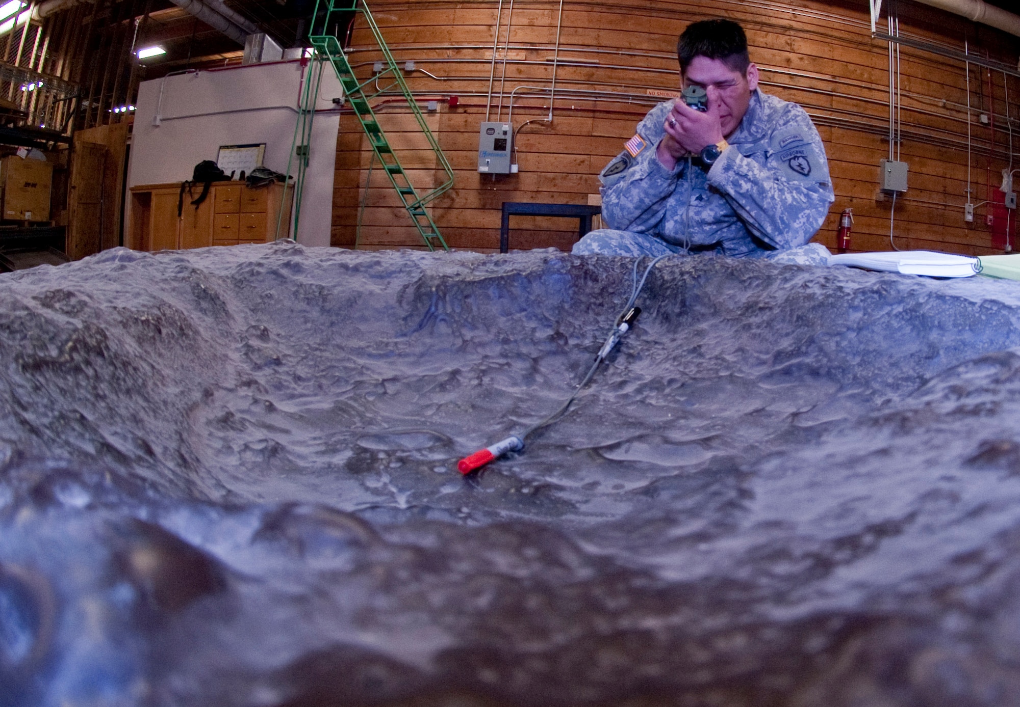 JOINT BASE ELMENDORF-RICHARDSON, Alaska ? Sgt. George Lee, 1st Squadron (Airborne), 40th Cavalry Regiment, analyzes a crater March 31. Members of the 1-40th did some hands-on training on how to analyze a crater, telling what type of munitions were used, where it came from, whether it was a high-angle or low-angle shot and approximately the distance the shot was taken. (U.S. Air Force photo by Senior Airman Christopher Gross)