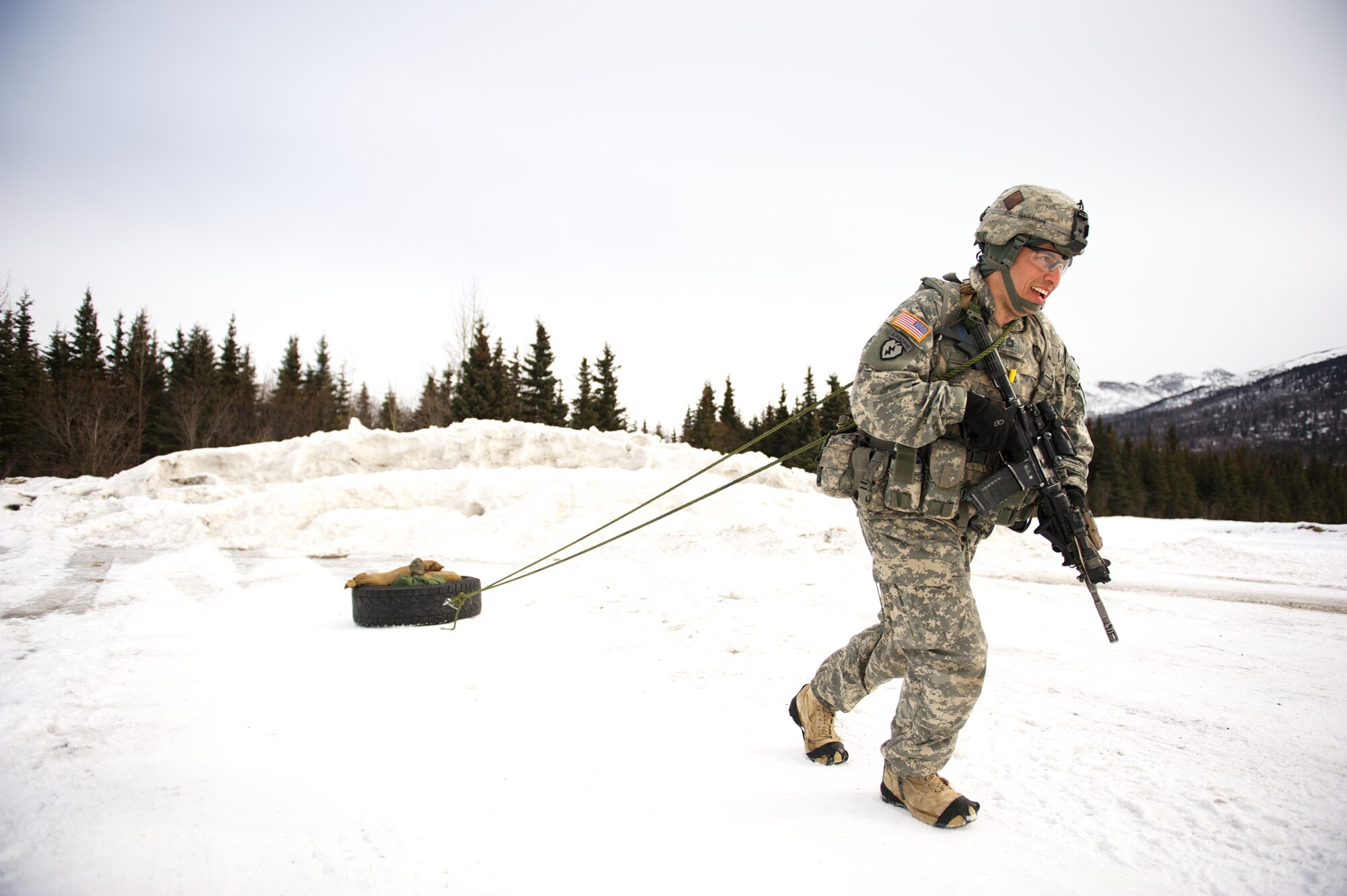 JOINT BASE ELMENDORF-RICHARDSON, Alaska ? Sgt. 1st Class Kenneth Rose, A Company, 1st Battalion, 501st Infantry Regiment (Airborne), drags a Humvee tire during the company's March 24 stress shoot at the Joint Base Elmendorf-Richardson range. (U.S. Air Force photo by David Bedard/released)