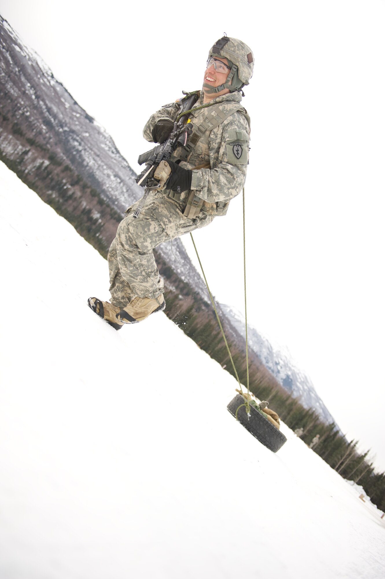 JOINT BASE ELMENDORF-RICHARDSON, Alaska ? Sgt. 1st Class Kenneth Rose, A Company, 1st Battalion, 501st Infantry Regiment (Airborne), drags a Humvee tire during the company's March 24 stress shoot at the Joint Base Elmendorf-Richardson range. (U.S. Air Force photo by David Bedard/Released)