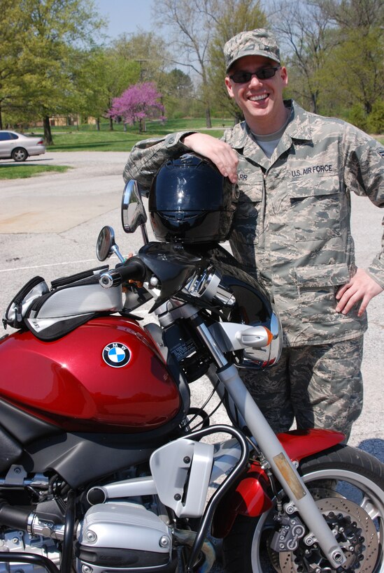 Tech. Sgt. Chris Parr holds on to his most important piece of motorcycle equipment--the helmet.  He reminds other riders to be safe.  A base-wide Motorcycle Safety Day is 14 April, and begins at 0900 with a mandatory Scott AFB Motorcycle Safety "All Call" for those who ride motorcycles in the Base Theater. Motorcycle Safety Day afternoon events will continue at the pavilions next to ALS starting at 11 a.m. until 3 p.m. The focus of the event is to promote motorcycle safety and rider awareness throughout Team Scott. All military, civilian, contractor riders and anyone who is considering operating or purchasing a motorcycle are invited to participate. (U.S. Air Force photo/Maj. Stan Paregien)