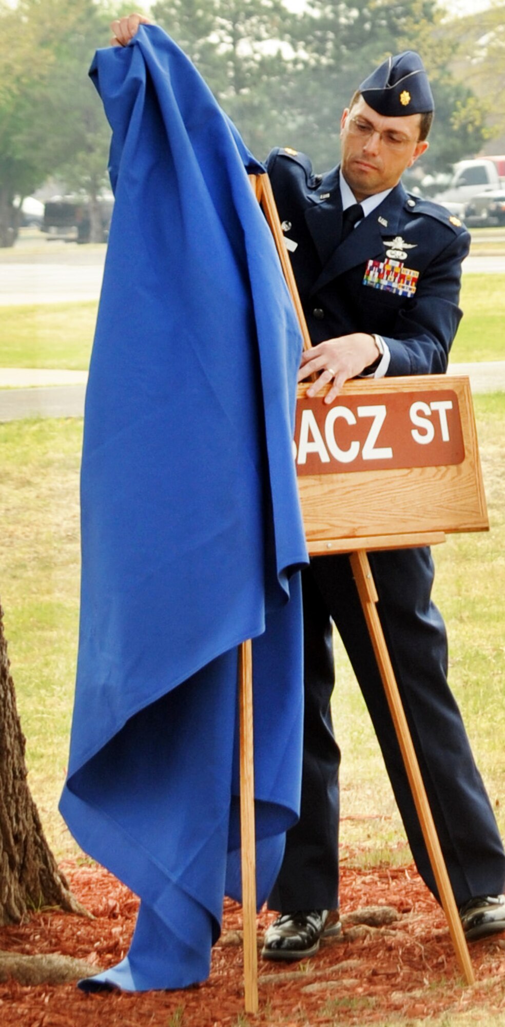 ALTUS AIR FORCE BASE, Okla. – Maj. Randy Wardak, 97th Communications Squadron commander, unveils a replica of the new Bubacz Street sign at Wings of Freedom Park here April 7. The street running alongside the 97th CS building, formerly known as 5th Street, was designated as Bubacz Street to honor Staff Sgt. Andrew S. Bubacz, who was the first and only Altus Airman to date to die while supporting Operation Enduring Freedom. The replica of the street sign was presented to Ashley Bubacz, widow of Sergeant Bubacz, who died Nov. 12, 2010, while deployed to Afghanistan. (U.S. Air Force photo by Airman 1st Class Kenneth W. Norman/ Released 97th Air Mobility Wing Public Affairs)