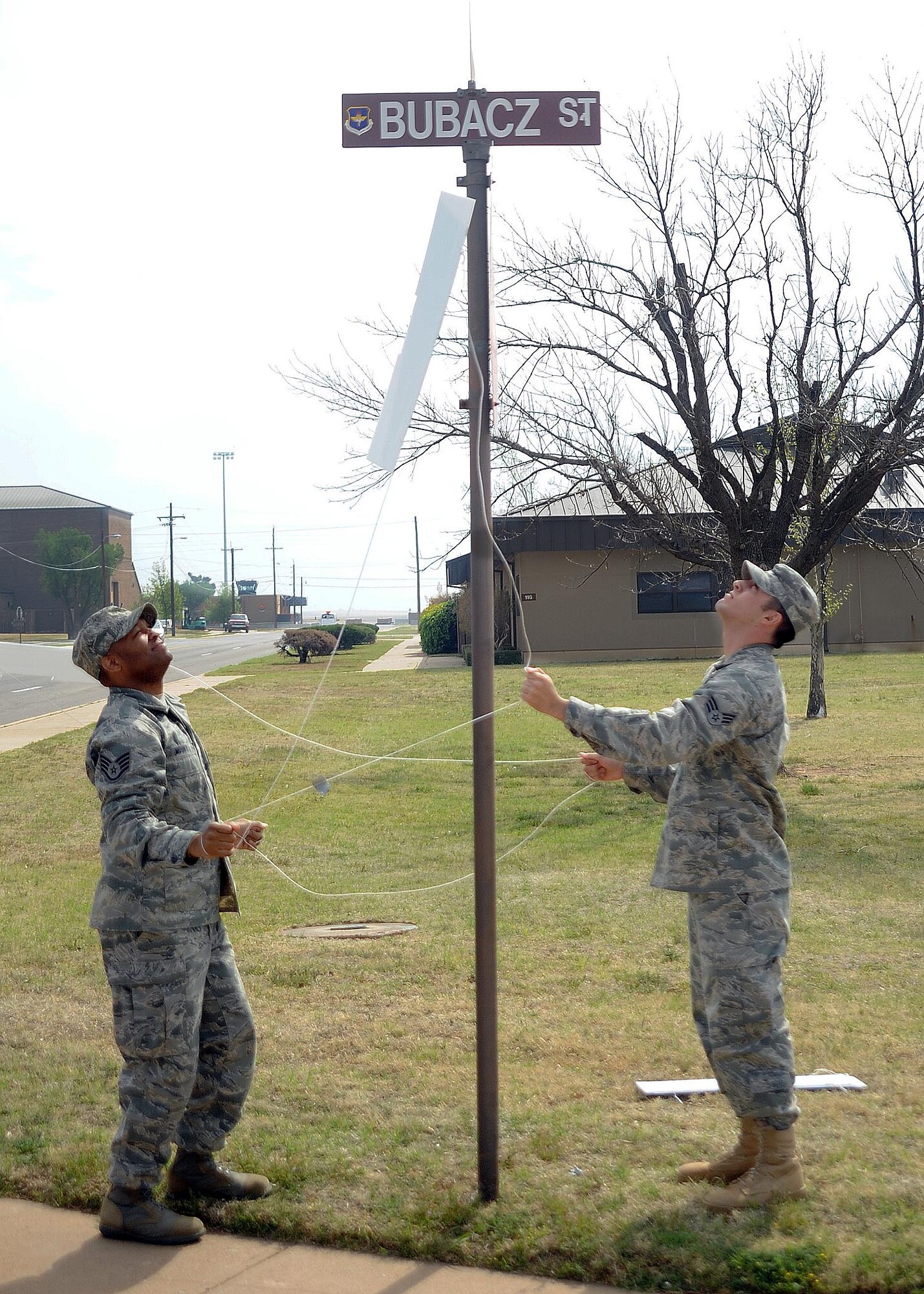 ALTUS AIR FORCE BASE, Okla. – Staff Sgt. Damien Mount and Senior Airman Brandon Rodriguez, both part of the 97th Communications Squadron, unveil Bubacz Street, formerly 5th Street, which runs next to the 97th CS building. The street was renamed during a ceremony April 7 in honor of Staff Sgt Andrew S. Bubacz, who was the first Altus Airman to die while supporting Operation Enduring Freedom. Sergeant Bubacz died Nov. 12, 2010,  while deployed to Afghanistan. (U.S. Air Force photo by Airman 1st Class Myles Stepp / 97th Air Mobility Wing Public Affairs)
