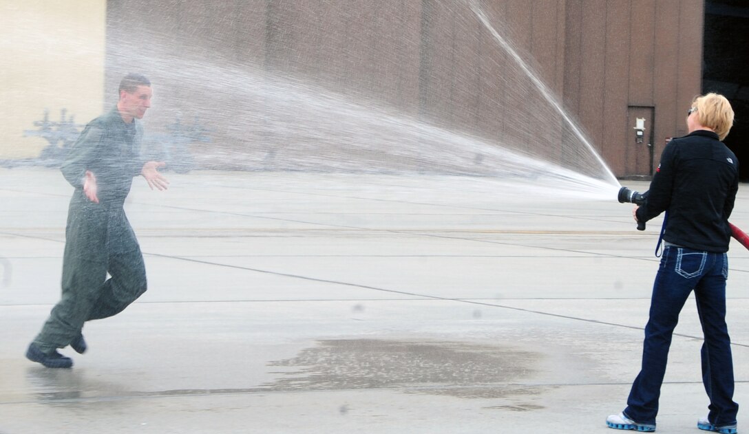(Left) Col. William Eldridge, 28th Operations Group commander, gets sprayed by his wife after his end of tour flight on a B-1B Lancer as the 28th OG commander at Ellsworth Air Force Base, S.D., April 5, 2011.  Colonel Eldridge has been the 28th OG commander since 2009. (U.S. Air Force photo/Senior Airman Anthony Sanchelli)