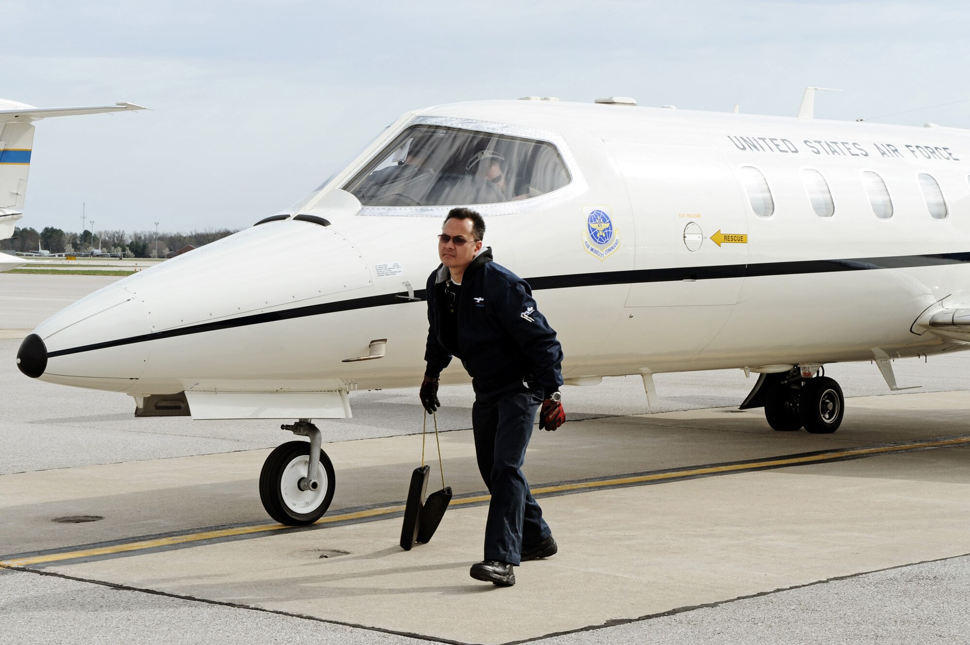 Steve Edwards, a DynCorp International contractor, pulls the chalks from a C-21A prior to takeoff April 6, 2011, at Scott Air Force Base, Ill. (U.S. Air Force photo/Staff Sgt. Brian J. Valencia)