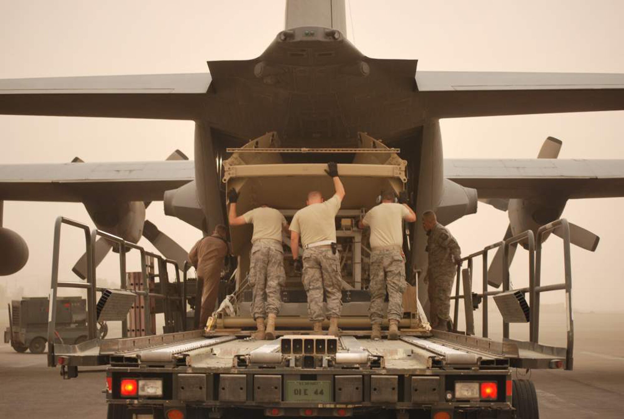 WRIGHT-PATTERSON AIR FORCE BASE, Ohio – 445th Airlift Wing reservist Tech. Sgt. Bob Castle (fourth from the left), 87th Aerial Port Squadron, ramp team chief, air transportation craftsman, helps Airmen from the 67th Aerial Port Squadron, Hill Air Force Base, Utah,  push equipment from a 60K loader onto a C-130 Hercules aircraft April 4.  All are currently deployed with the 332nd Expeditionary Logistics Readiness Squadron, Joint Base Balad, Iraq. (U.S. Air Force photo/Senior Master Sgt. Jack B. Lake, III)