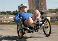 Tech. Sgt. Israel Del Toro, 342nd Training Squadron, steers his custom made recumbent bike past Forbes Hall during a training ride at the Lackland Training Annex April 5. The recumbent bike 10K is one of five events Sergeant Del Toro is preparing for in anticipation of his participation in the 2011 Wounded Warrior Games May 16-21. (U.S. Air Force photo/Robbin Cresswell)