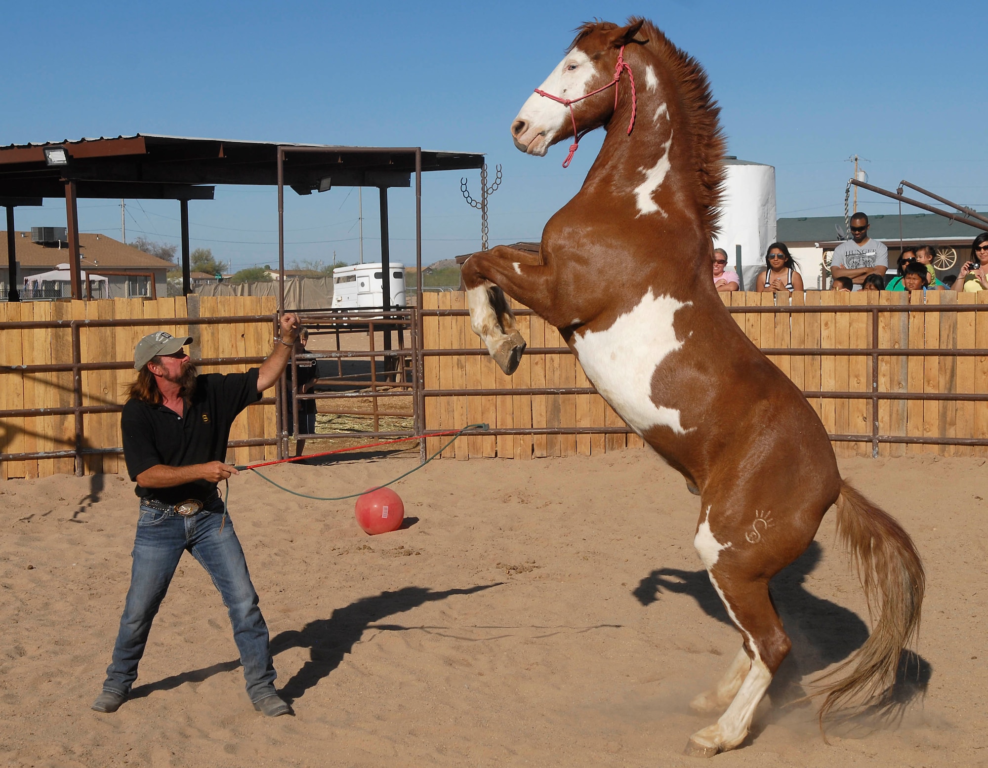 Sunset Ranch owner, Gary "BadDog" Bennett instructs his famous horse, Blue-eyed Jack, to perform tricks April 3 during the Hearts Apart event at Sunset Ranch in Buckeye, Ariz. Mr. Bennett is a rodeo clown, wild west entertainer and a seven time World and National Champion Cowboy Mounted Shooter. When not performing, he specializes in fixing horses with behavior issues and training mounted shooting horses.
 (U.S. Air Force photo/Senior Airman Darlene Seltmann)