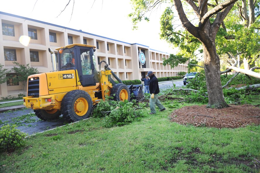 Debris from fallen trees and limbs is cleared away from the front of Bldg. 215. U. S. Air Force photo by Raymond Crayton Jr 