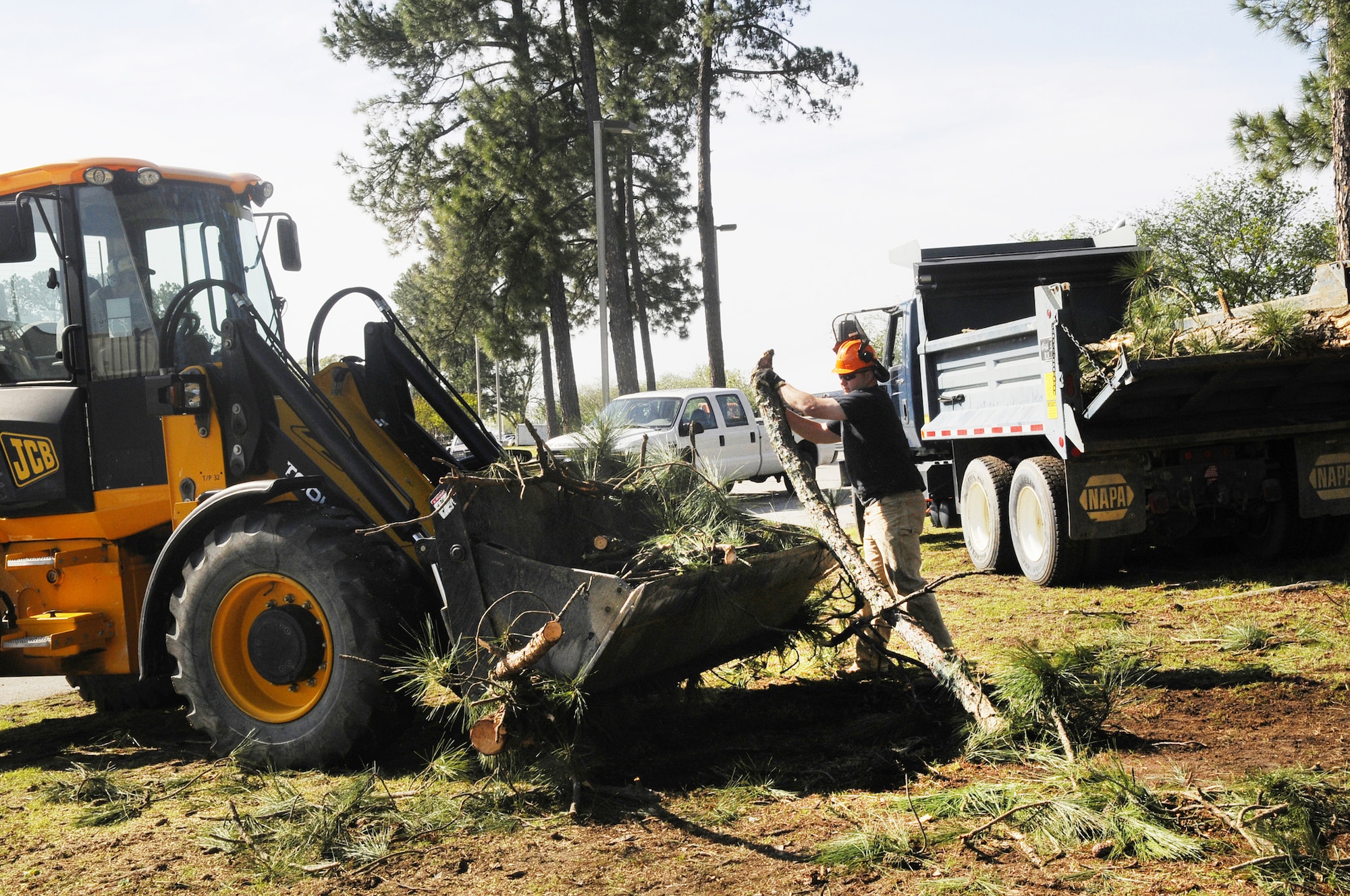 CE workers clean up fallen branches near Bldg. 207 Tuesday. U. S. Air Force photo by Sue Sapp
